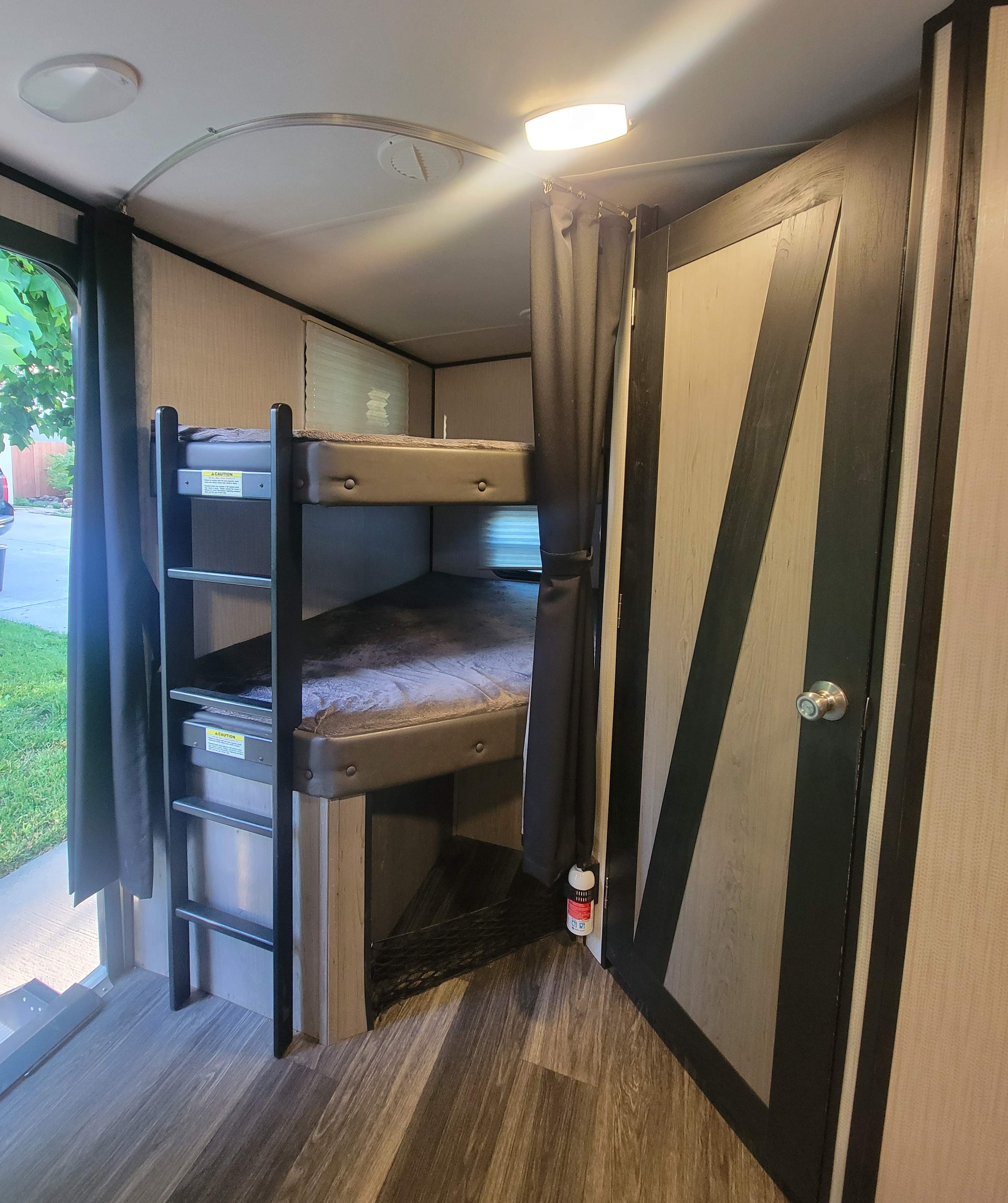 RV rental interior showing bunk beds with an attached ladder, durable flooring, and a modern barn door. Great for families.. Heartland RVs Mallard 2021