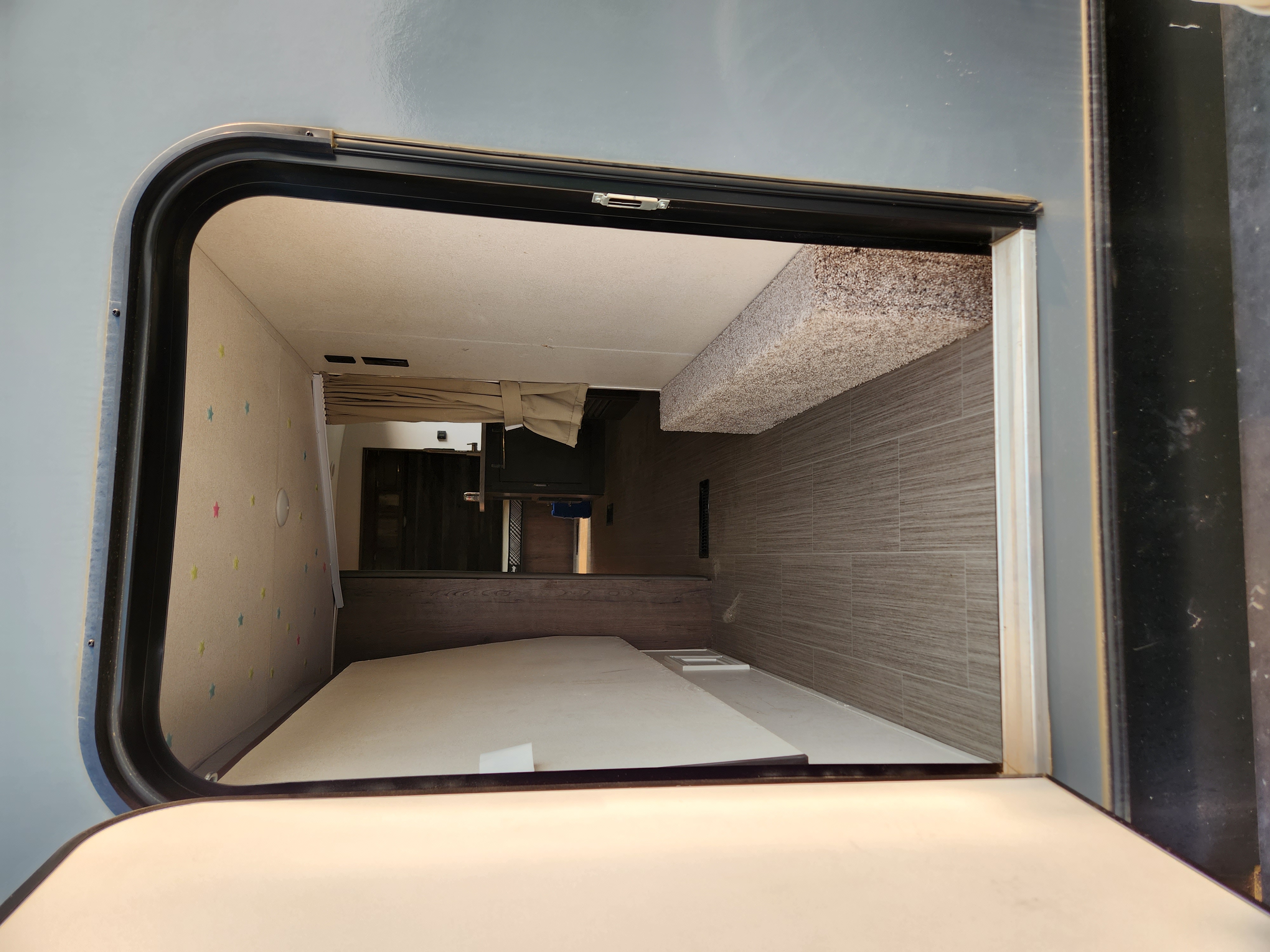 Cozy RV rental interior with bunk beds, main sleeping area, and living space visible from the open door.. Keystone RV Passport GT 2021