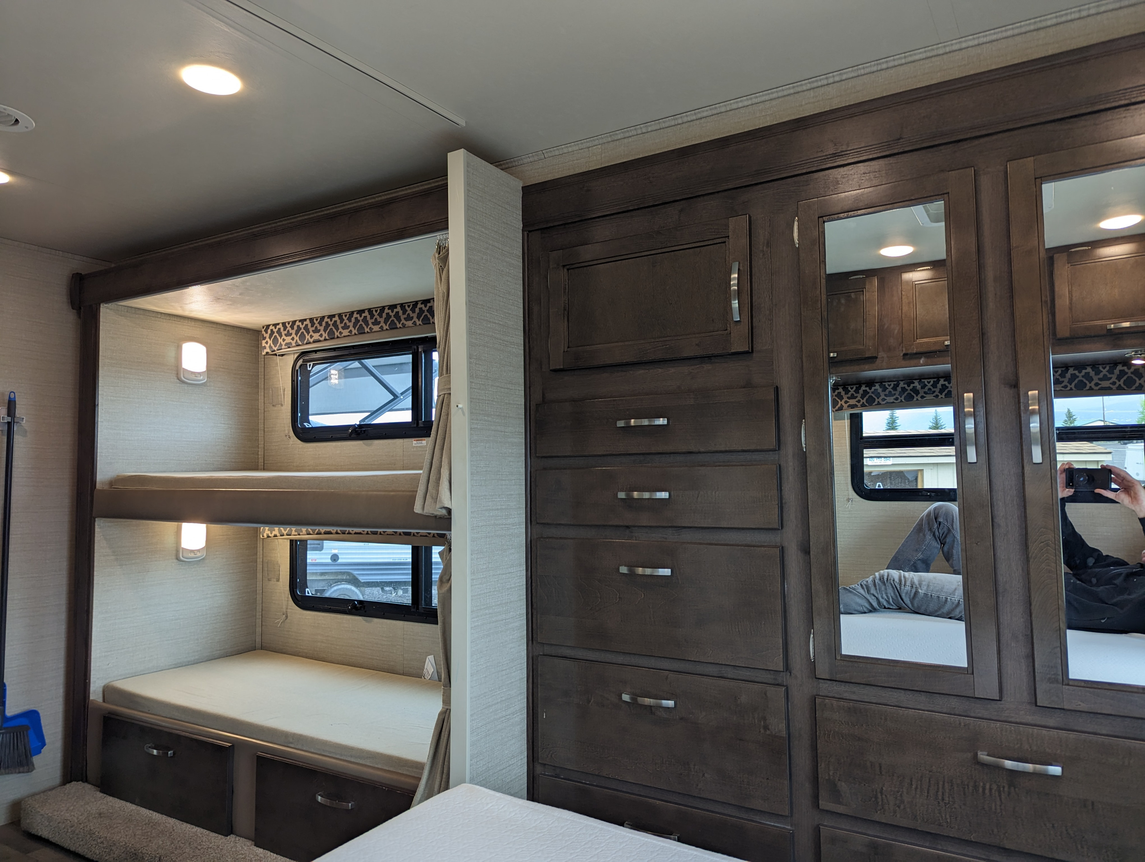 RV rental with modern interior: bunk beds, built-in lights, windows, and dark wood cabinetry with mirrored storage doors.. Jayco Redhawk 2019