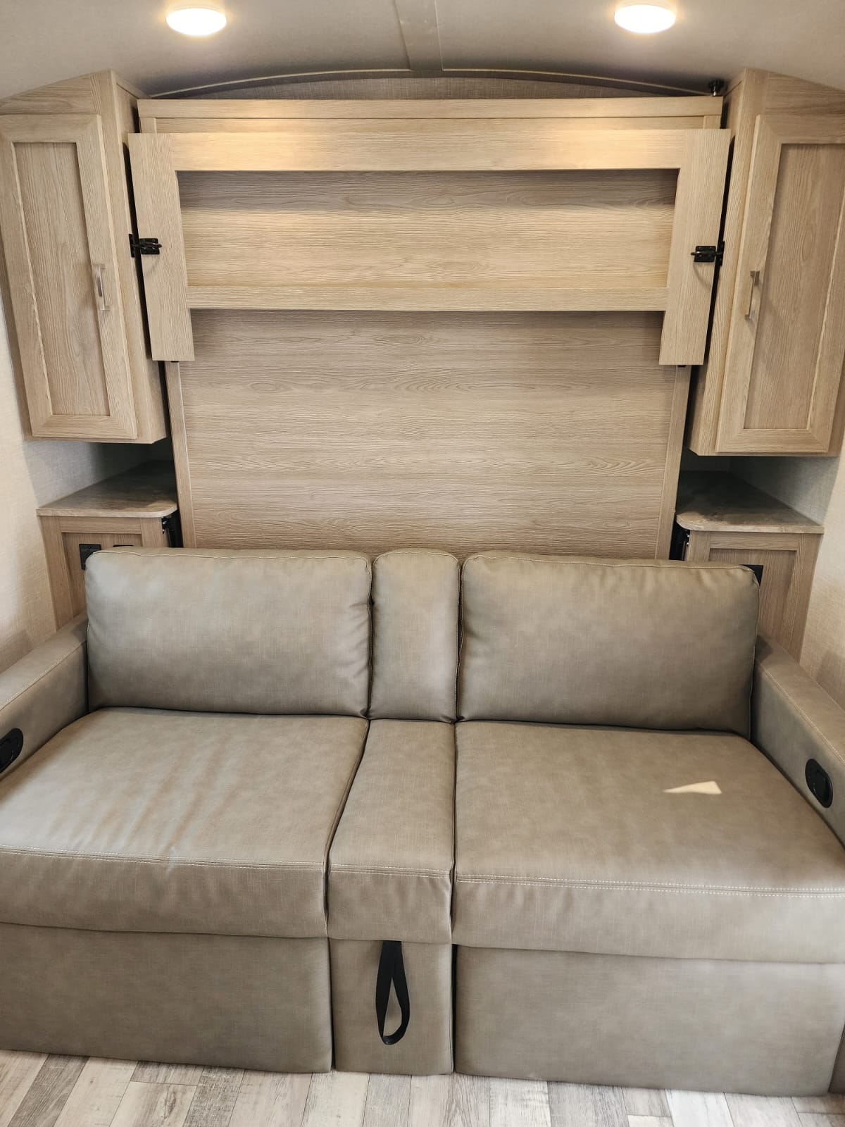 Modern rv rental interior with a light wood murphy bed above a convertible sofa, maximizing space and comfort.. Forest River Rockwood Geo Pro 2022