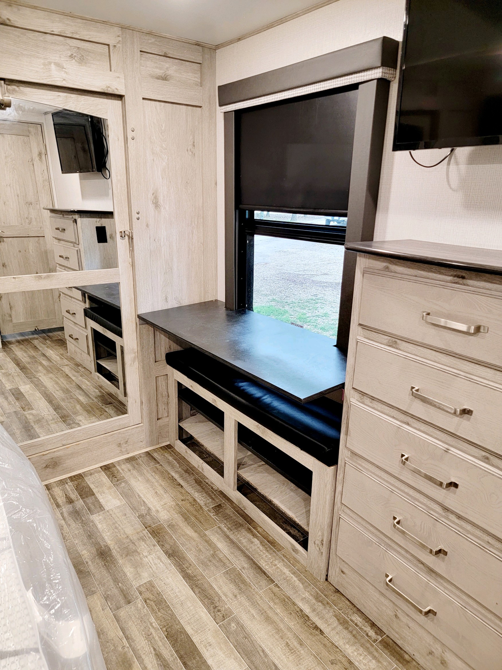 RV rental: light wood bedroom with large mirror, desk, padded bench, dresser, window, and TV.. Keystone Avalanche 2021