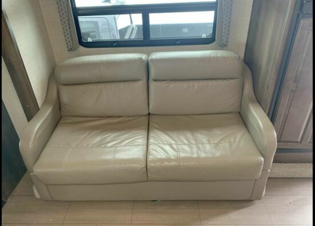 Light-colored, two-seater sofa inside an RV rental. Cozy interior seating for your next adventure.. Jayco Greyhawk 2018