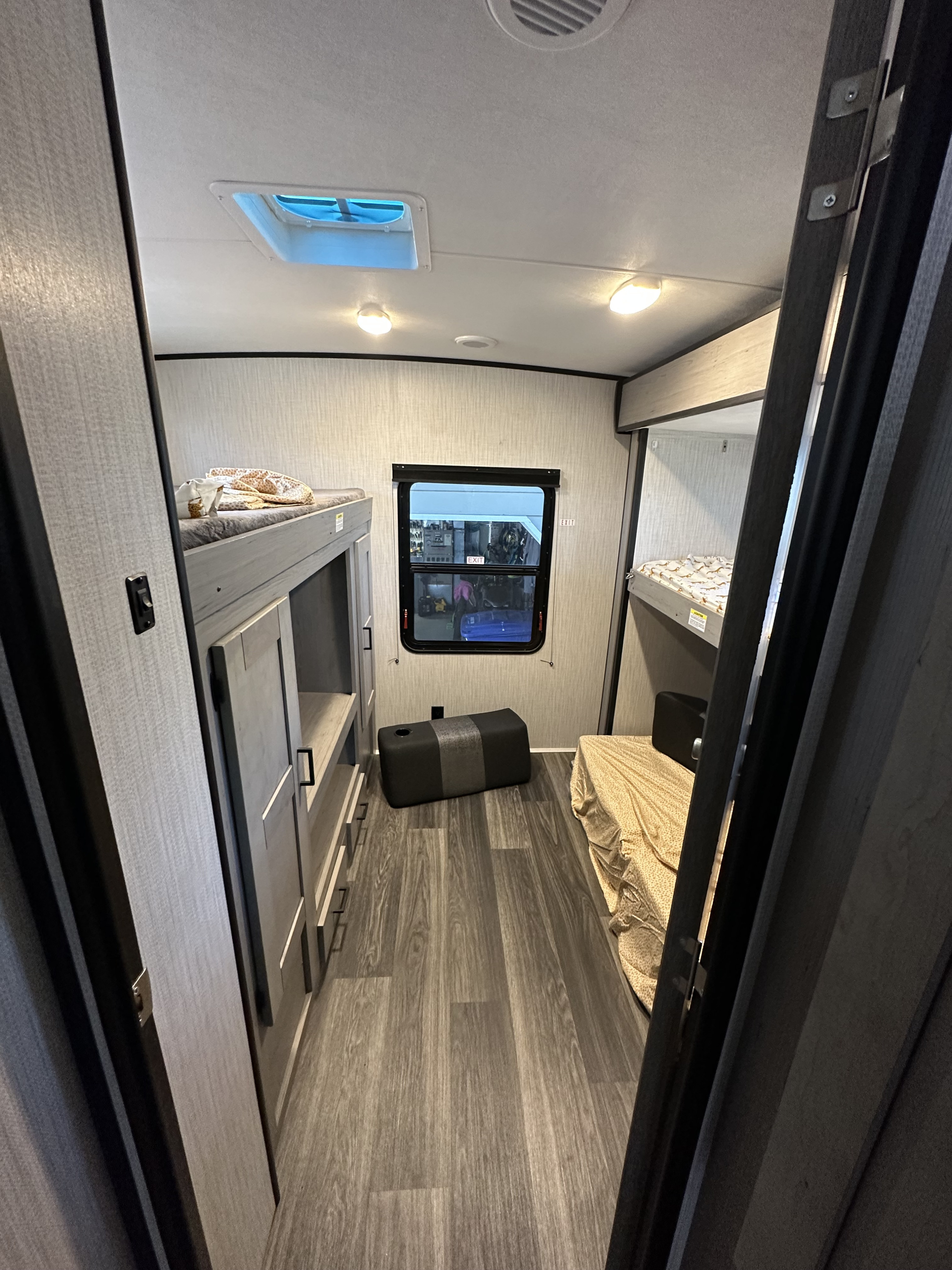 Modern RV rental bunkhouse interior: Two sets of bunk beds, ample storage, and a large window provide comfort and space.. Heartland RVs Mallard 2022