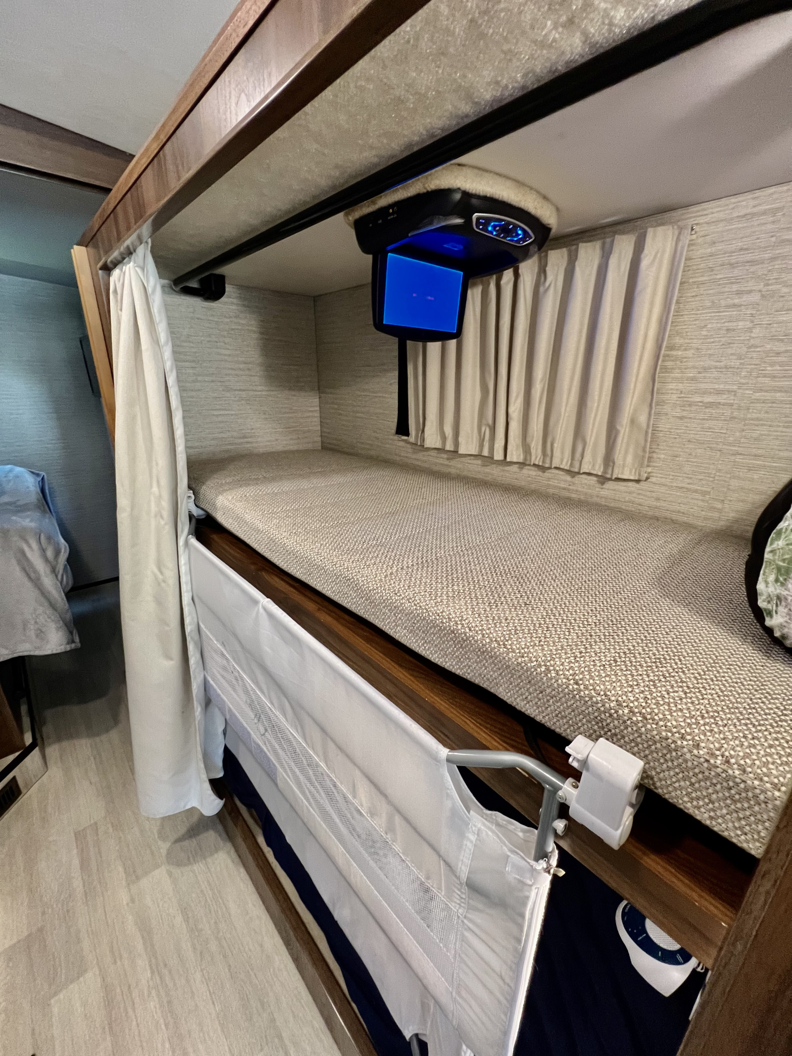 This RV rental offers a comfortable bunk bed with an overhead TV and side safety rail.. Winnebago Vista 2021