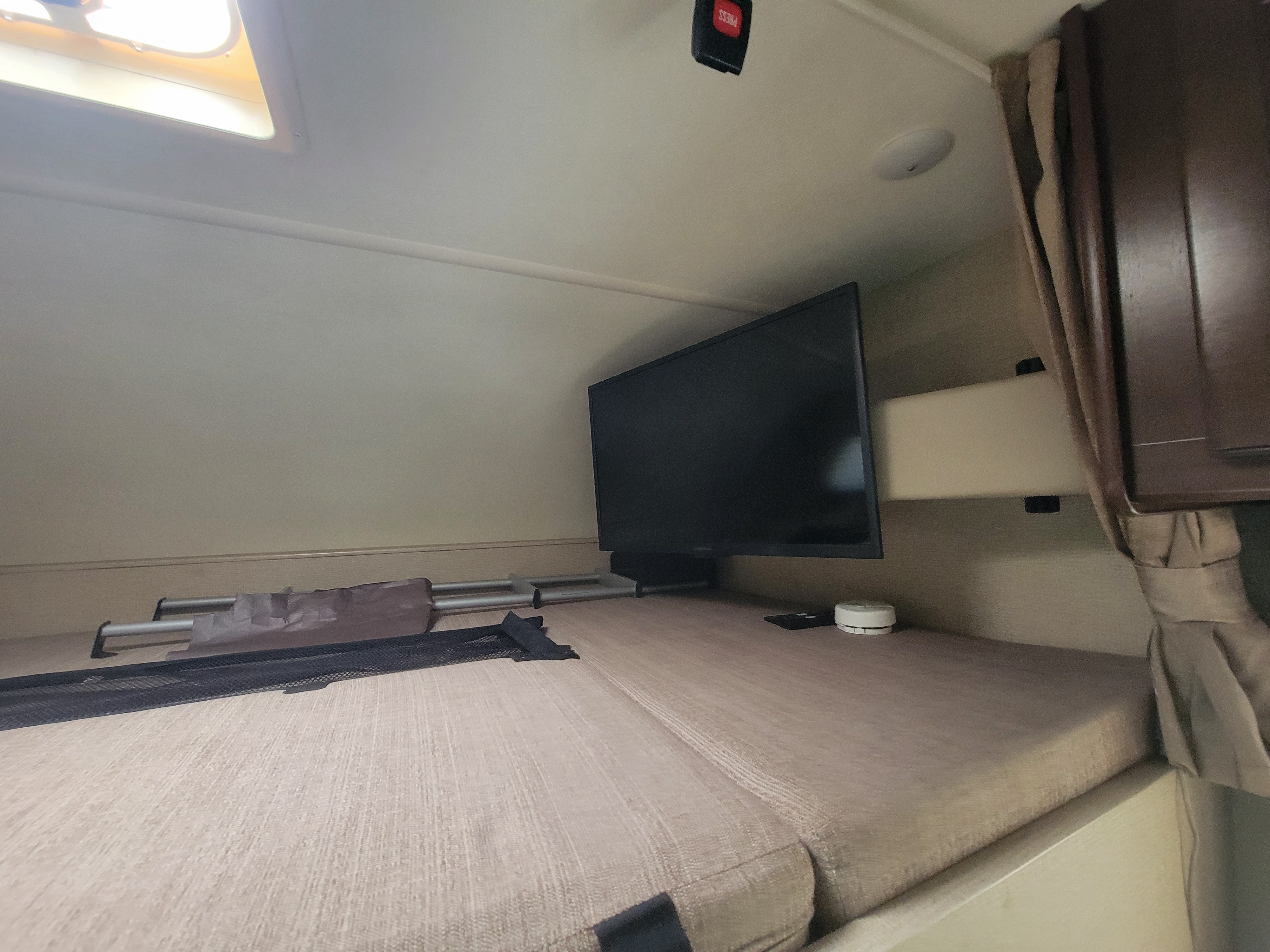 RV rental: view of the front overcab bunk with TV, safety net, and skylight.. Thor Four Winds 2020