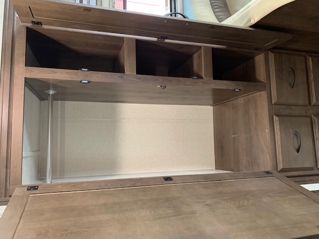Interior of an RV rental showing a clever built-in desk area with overhead storage cubbies and drawers.. Other Other 2018
