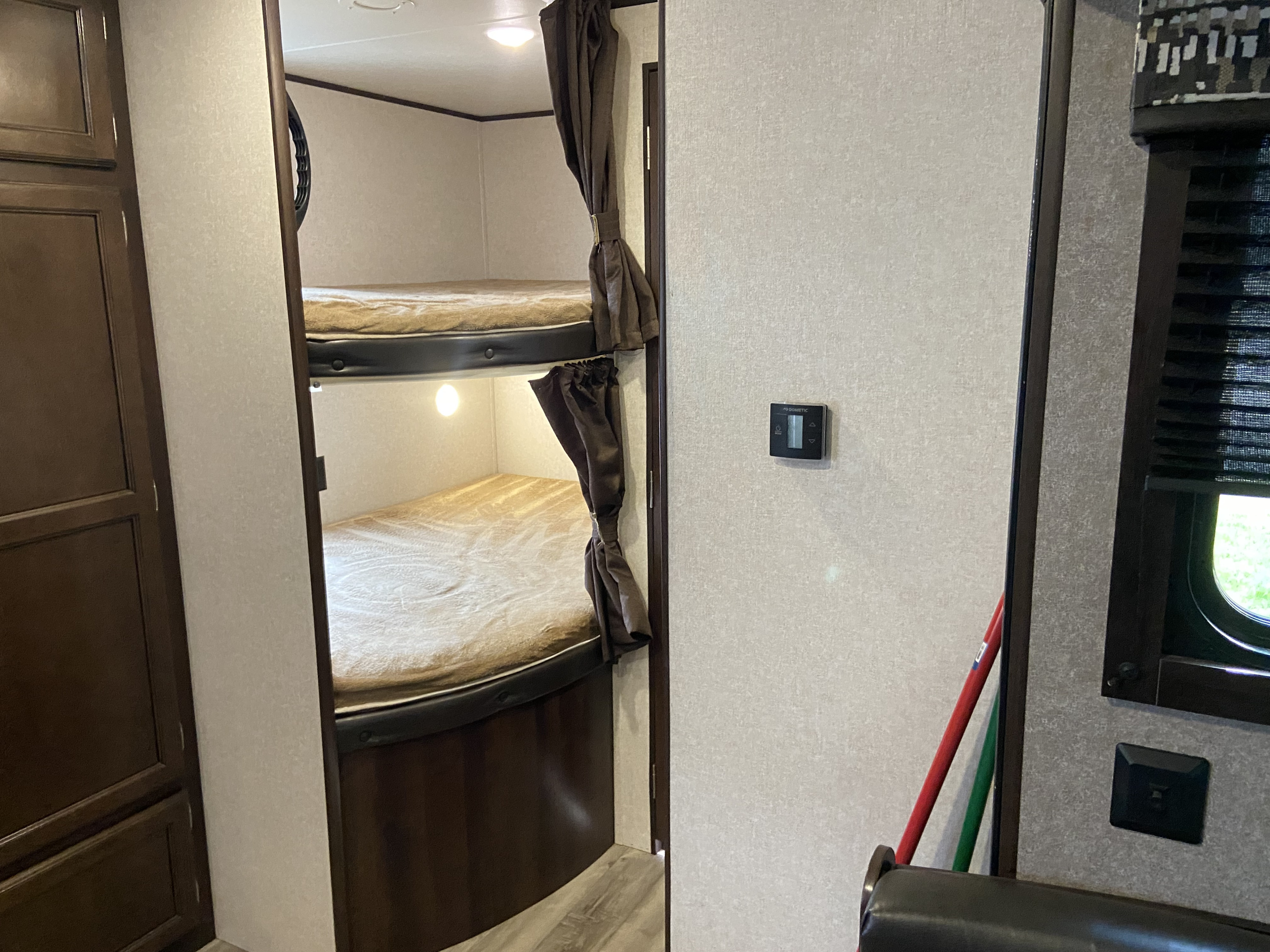 Inside an RV rental: Comfortable bunk beds with privacy curtains and individual lights. Features include a Dometic thermostat.. Jayco Jay Flight SLX 2018