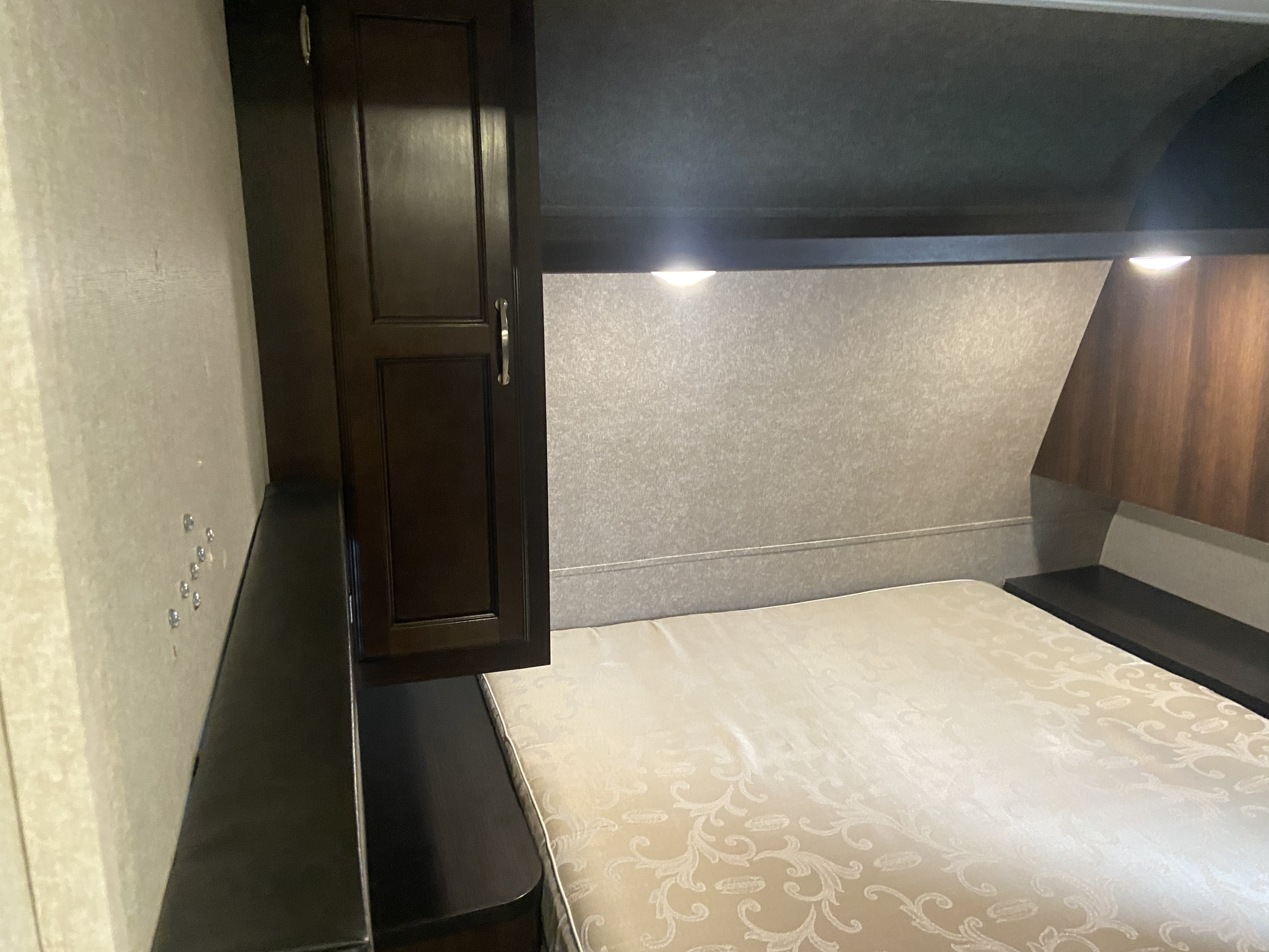 Cozy RV bedroom interior for your next RV rental. Features a comfortable bed, cabinet, and ambient lighting.. Jayco Jay Flight SLX 2018
