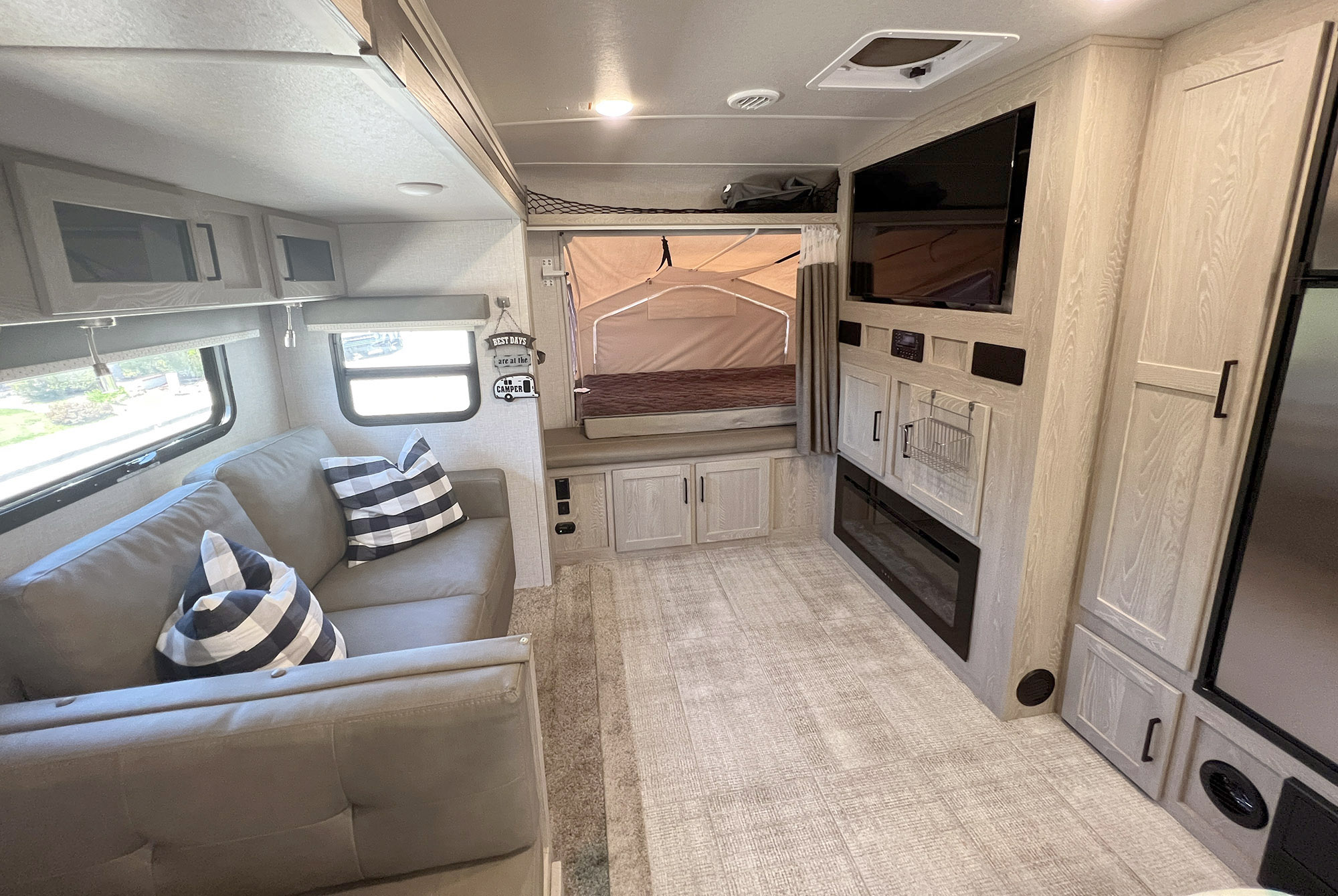 Modern RV rental interior features a comfy living area, pop-out bed, entertainment center with TV/fireplace, and ample storage.. Forest River Rockwood Roo 235S