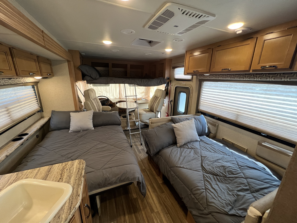 RV rental interior featuring two floor beds, an overhead bunk, and a dinette area.. Thor Motor Coach A.C.E 2017