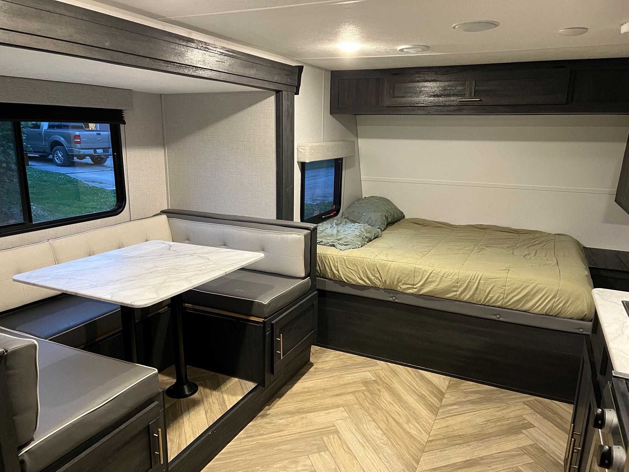 Cozy RV rental interior featuring a modern dinette area and a comfortable full bed. Ready for your adventure!. Forest River Ozark 2700TH 2022