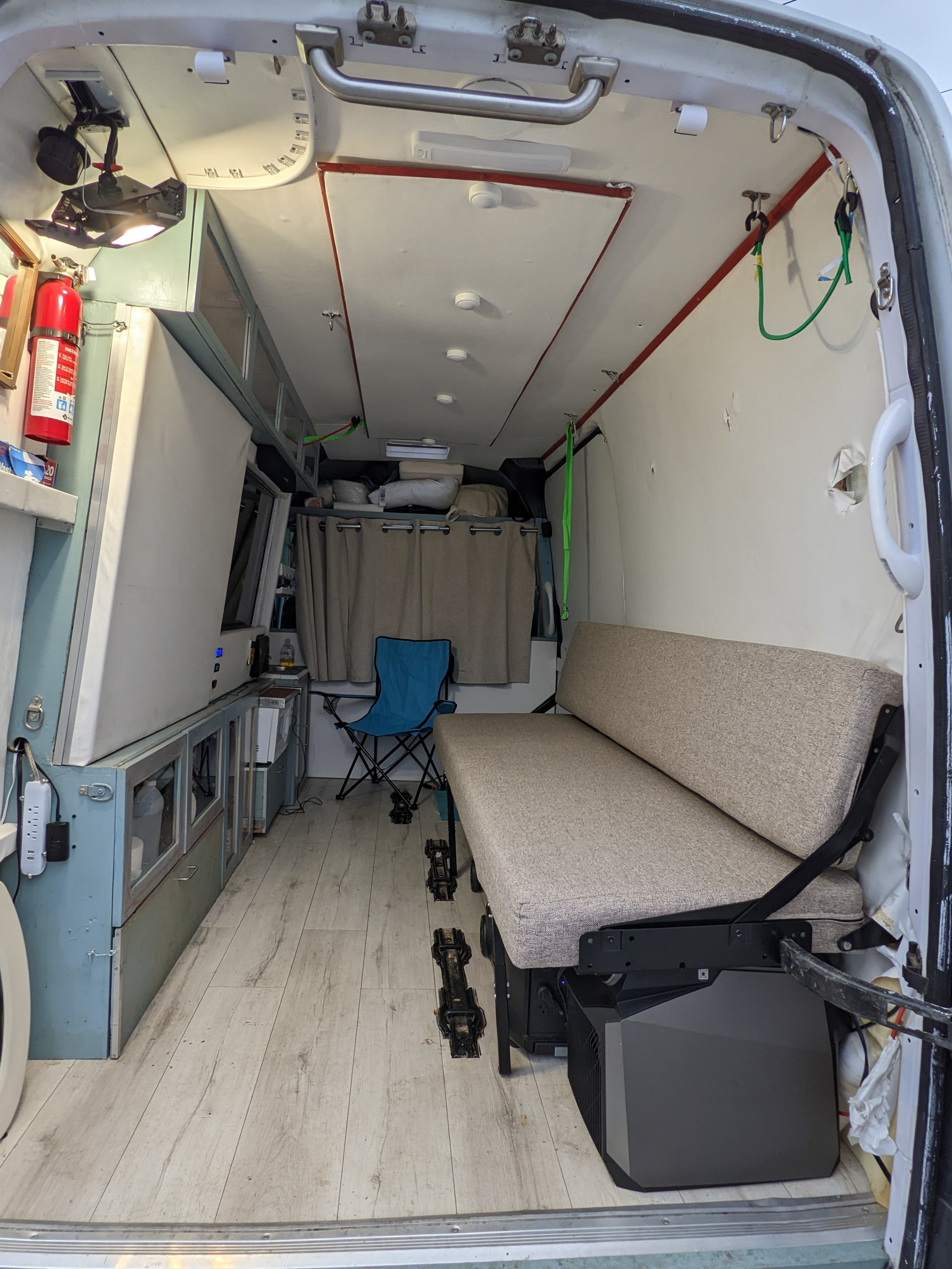 RV rental van interior: a functional custom-built space with versatile seating, storage, and mobile power for compact camper travel.. Mercedes Benz Sprinter 2500 144 2007
