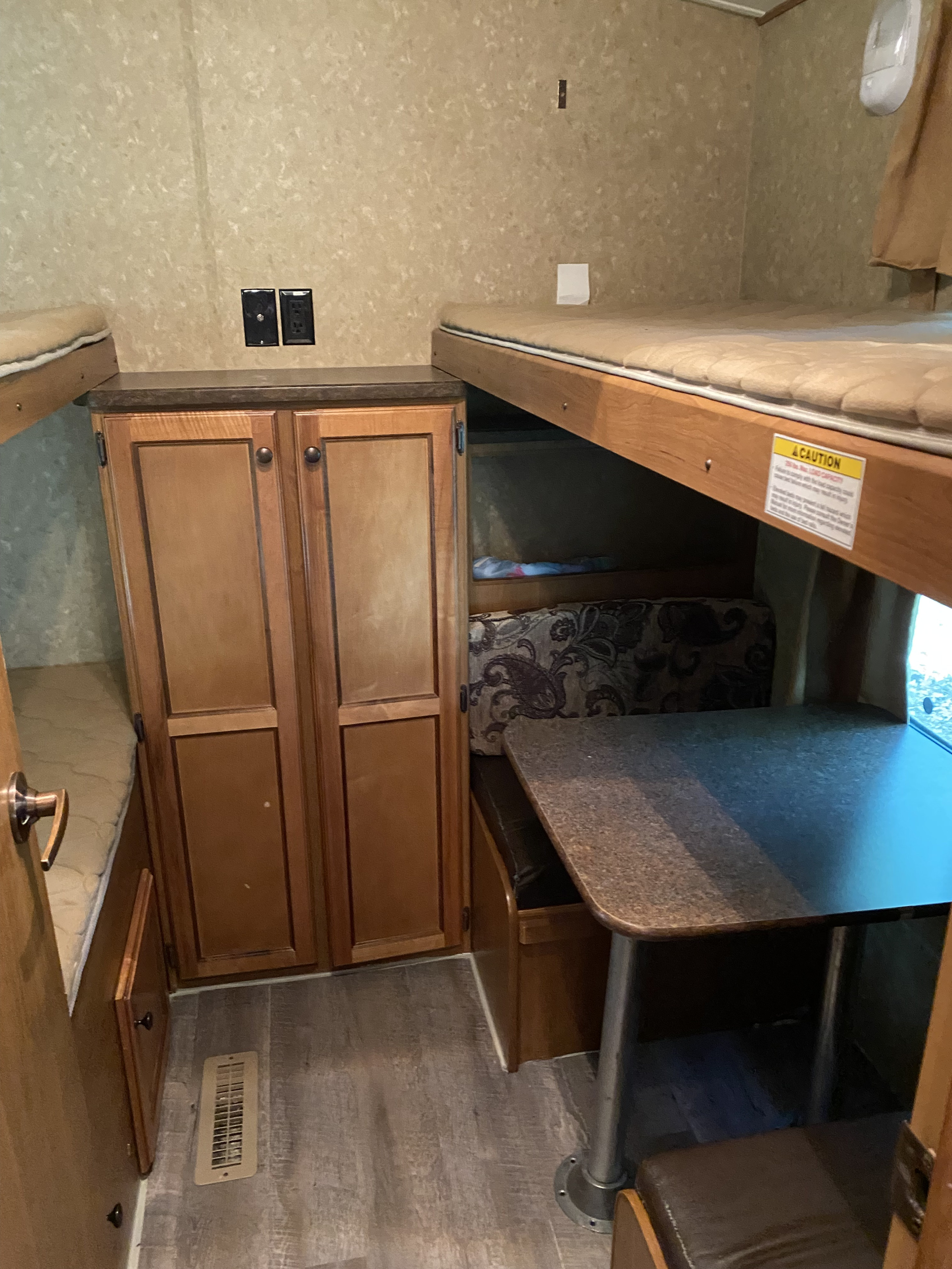 RV rental interior features comfortable bunk beds, a central wardrobe, and a functional dinette, ideal for travel.. Crossroads RV Sunset Trail Super Lite 2012