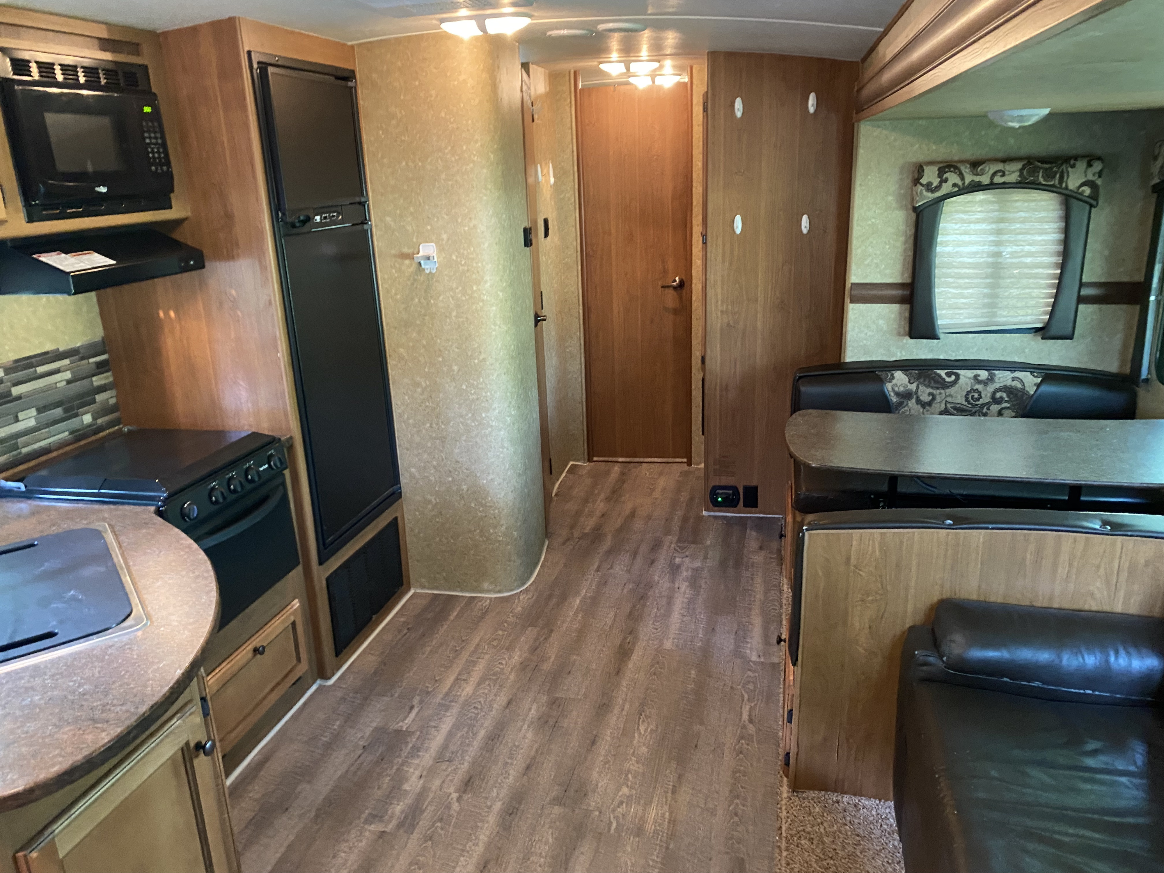 Interior view of an RV rental, showcasing its well-equipped kitchen, comfortable dining area, and spacious layout.. Crossroads RV Sunset Trail Super Lite 2012