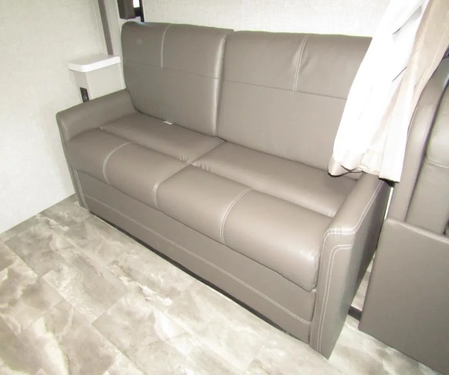 This RV rental's gray faux-leather sofa offers stylish and comfortable seating in a compact interior.. Thor Quantum 2023
