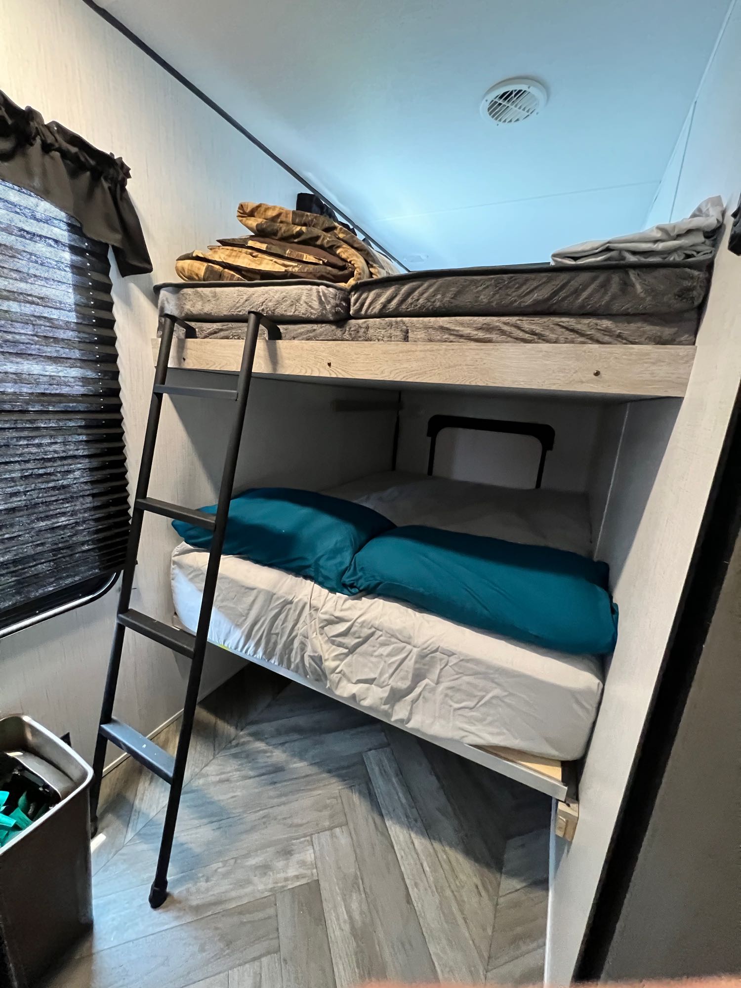 Two compact bunk beds with a ladder in an RV rental, offering cozy sleeping space.. Heartland RVs Prowler 2022