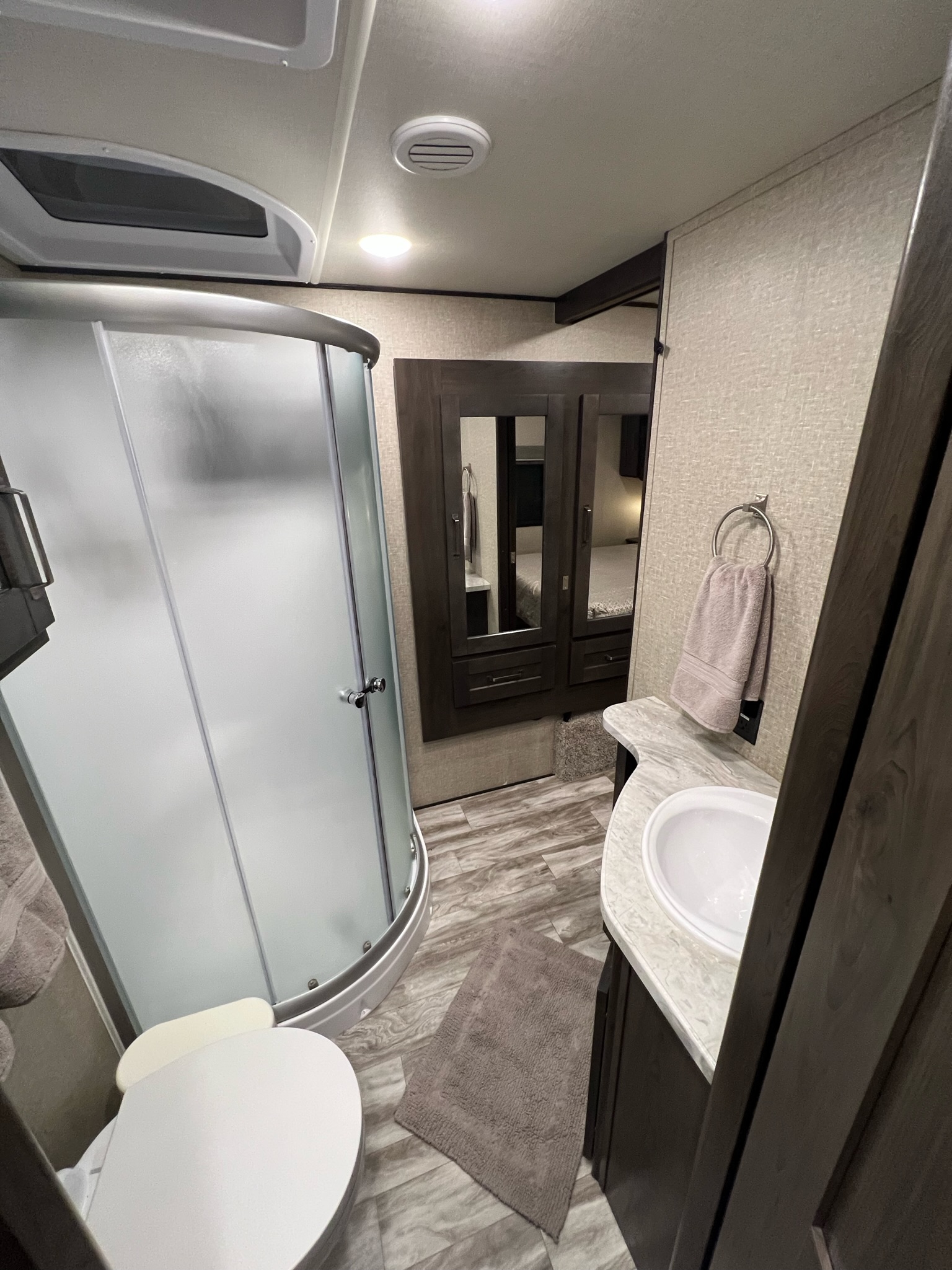 This RV rental offers a well-appointed bathroom with a frosted glass shower, toilet, and modern vanity with sink.. Grand Design Reflection 2021