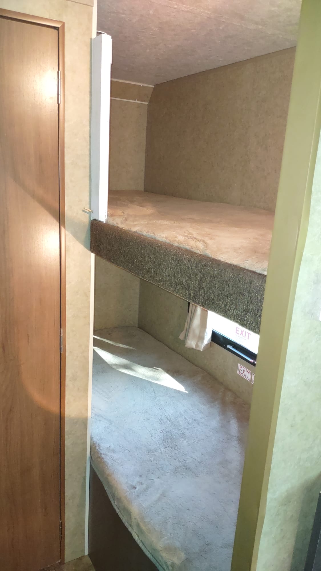 RV rental bunk beds, with a closet door and emergency exit window, offer comfortable sleeping in this interior view.. Starcraft Launch 2013