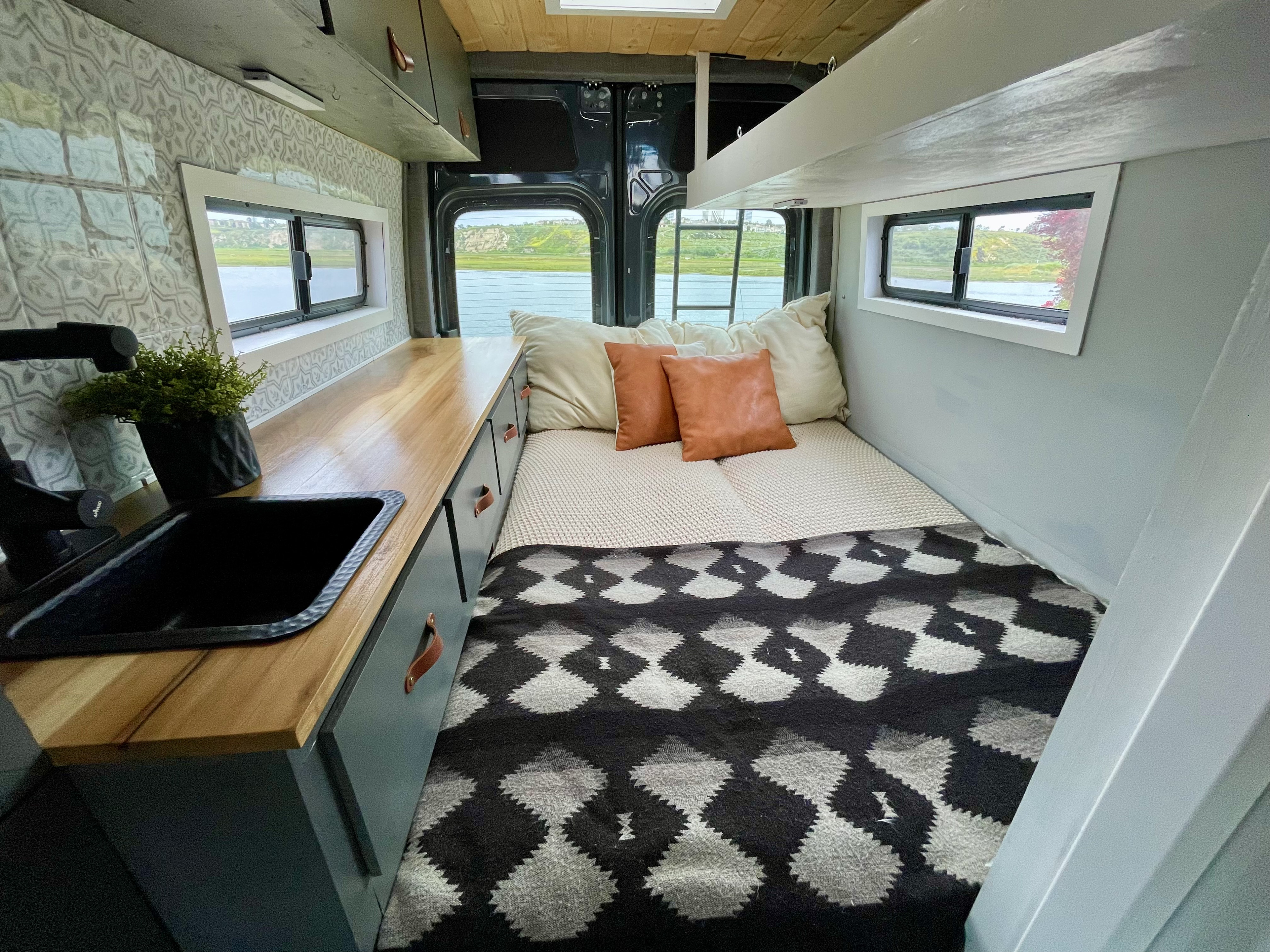 This cozy RV rental features a full bed, built-in kitchen counter with a sink, and scenic window views of the outdoors.. Mercedes Sprinter Sprinter 2500 2021