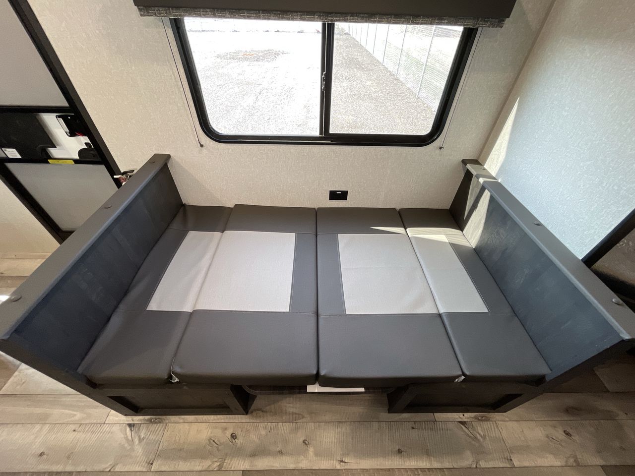 RV rental interior: Grey and white dinette with convertible cushions next to a window.. KZ Sportsmen SE 260BHSE 2022