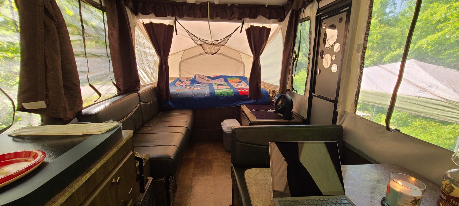 RV rental interior. Relax in this cozy pop-up camper with a bed, sofa, dinette, and nature views. Ideal for camping.. Forest River Rockwood ESP 2017