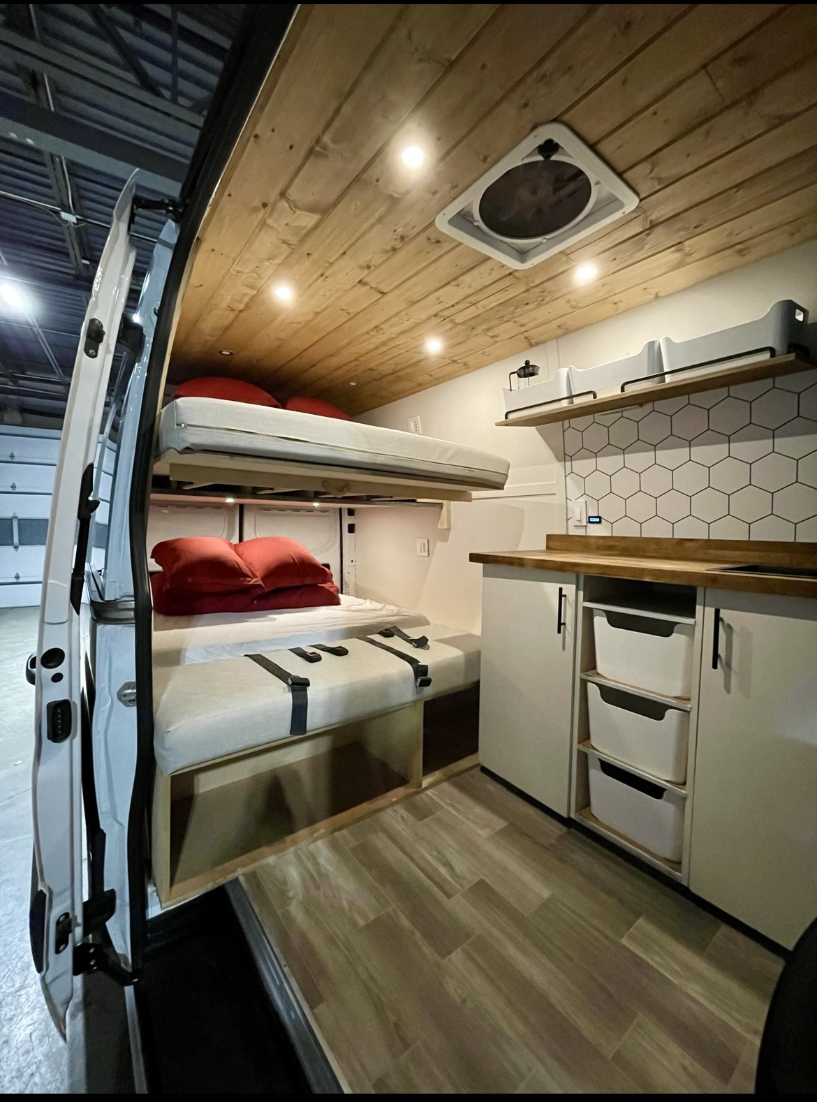 Modern rv rental interior featuring bunk beds, a wood ceiling with fan, organized kitchen, and ample storage.. Mercedes-Benz Sprinter 2021