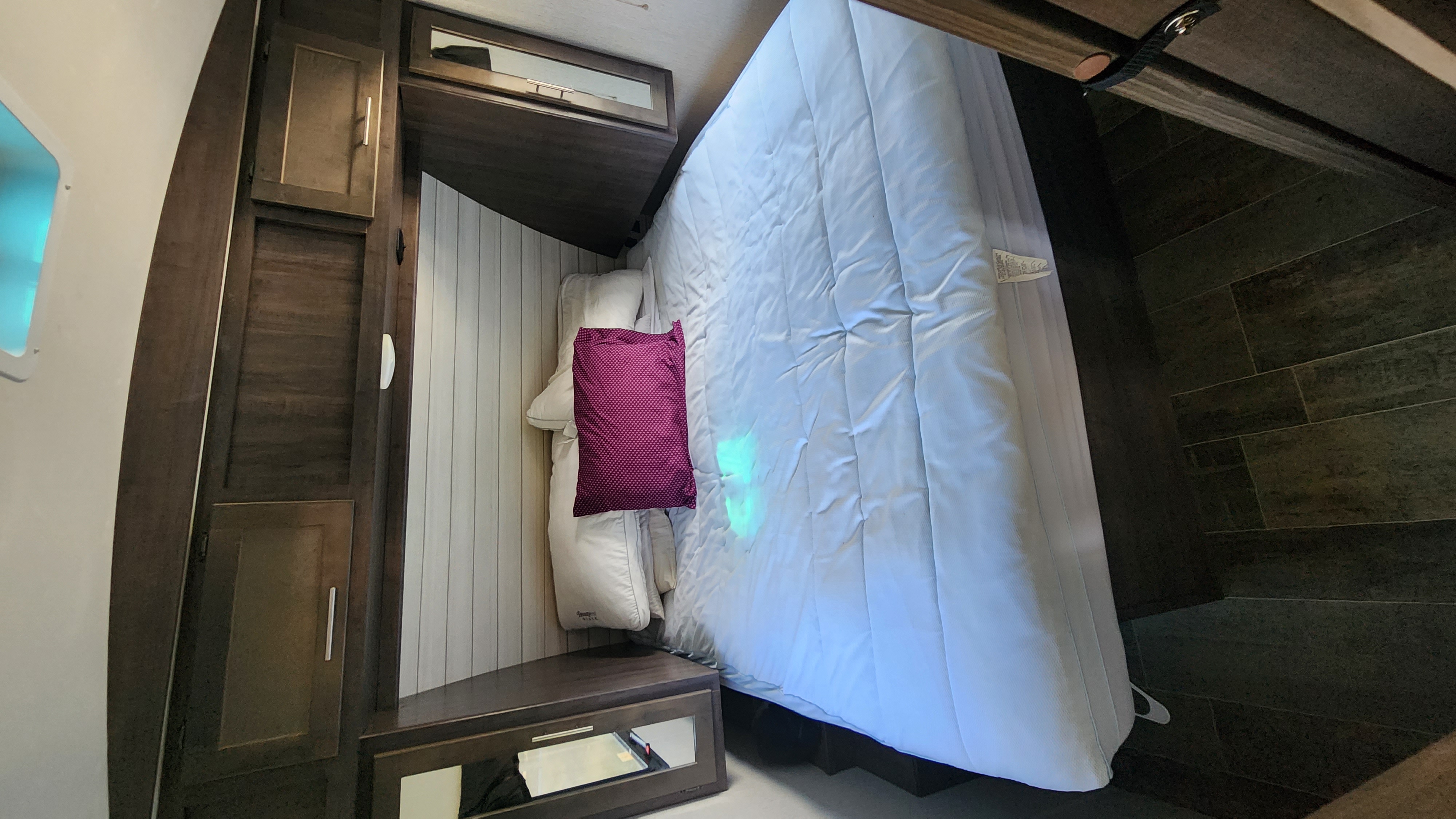 Cozy RV rental bedroom interior featuring a comfortable bed, wooden cabinets, and a window. Perfect for your travel adventures.. Crossroads RV Sunset Trail Super Lite 2019