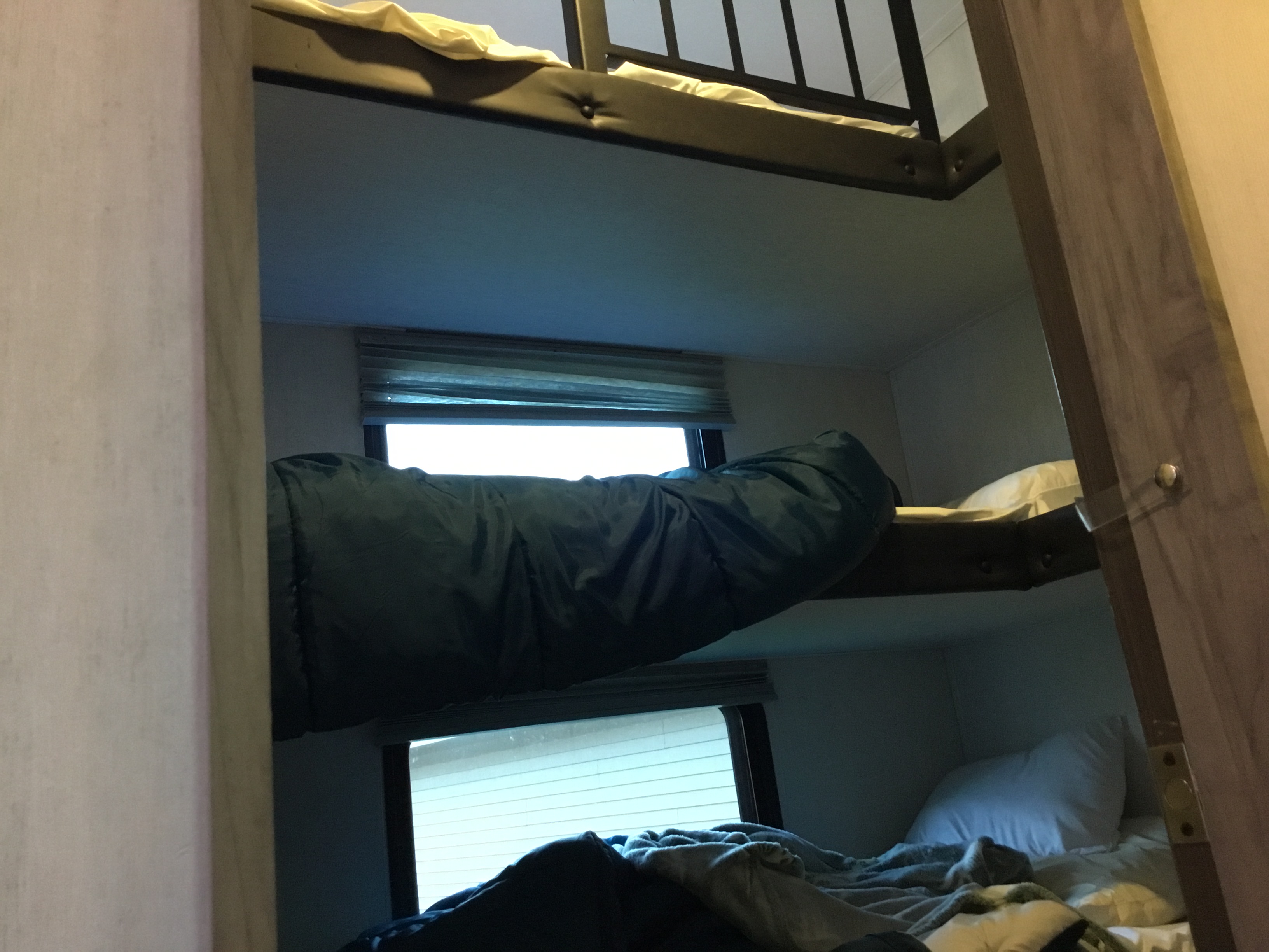 Inside an RV rental: tiered bunk beds with cozy bedding and windows, providing a comfortable sleeping area for your travel adventures.. Forest River Arctic wolf 325 MB 2023