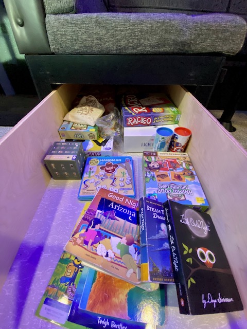 This RV rental drawer holds neatly stored games like Racko and "Little Owl Night" books, perfect for family fun.. Forest River Cherokee Grey Wolf 2022