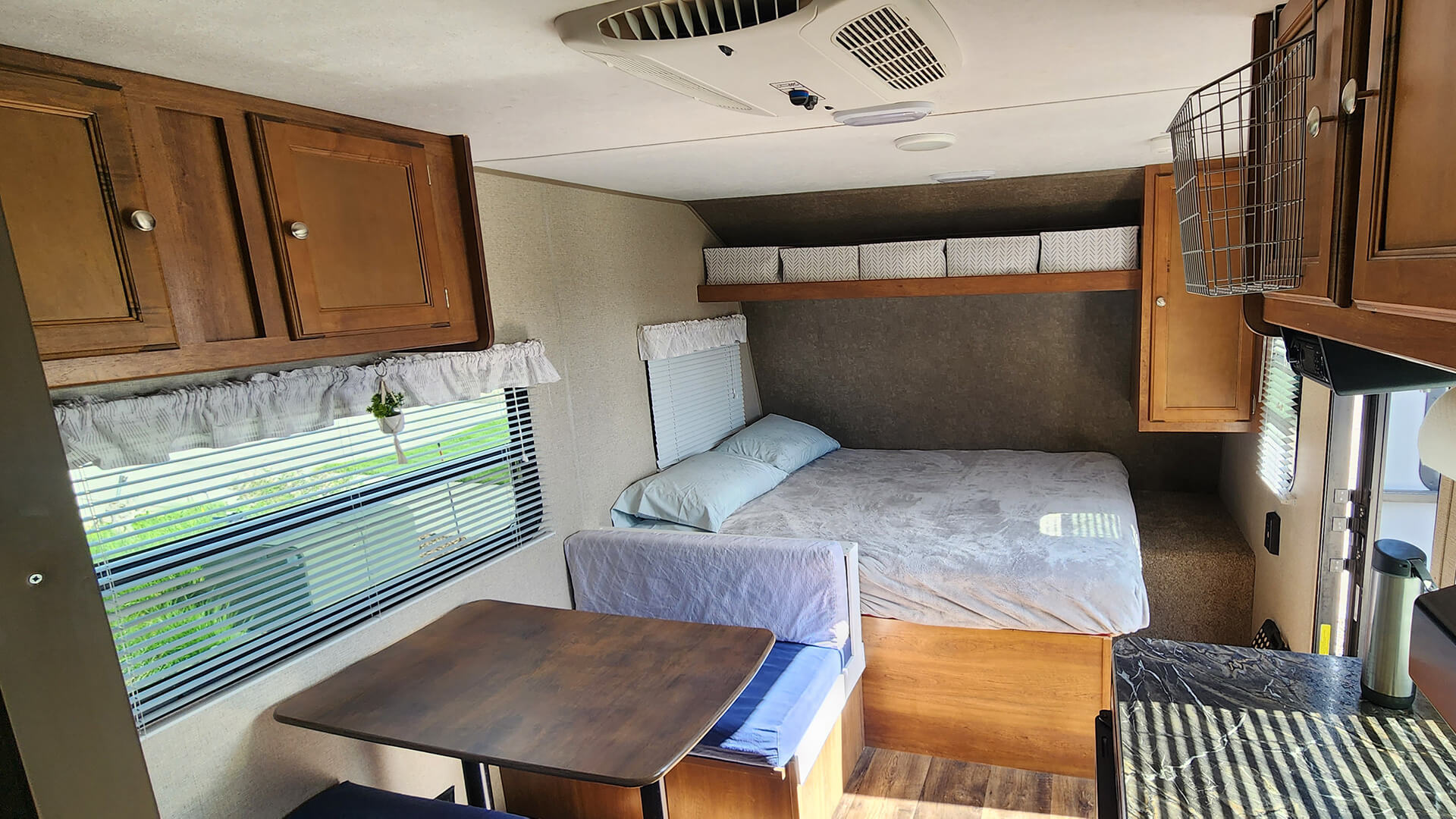 Interior of a comfortable RV rental, featuring a bed, a dining dinette, and a partial view of the kitchen counter.. Keystone RV Summerland Mini 2017
