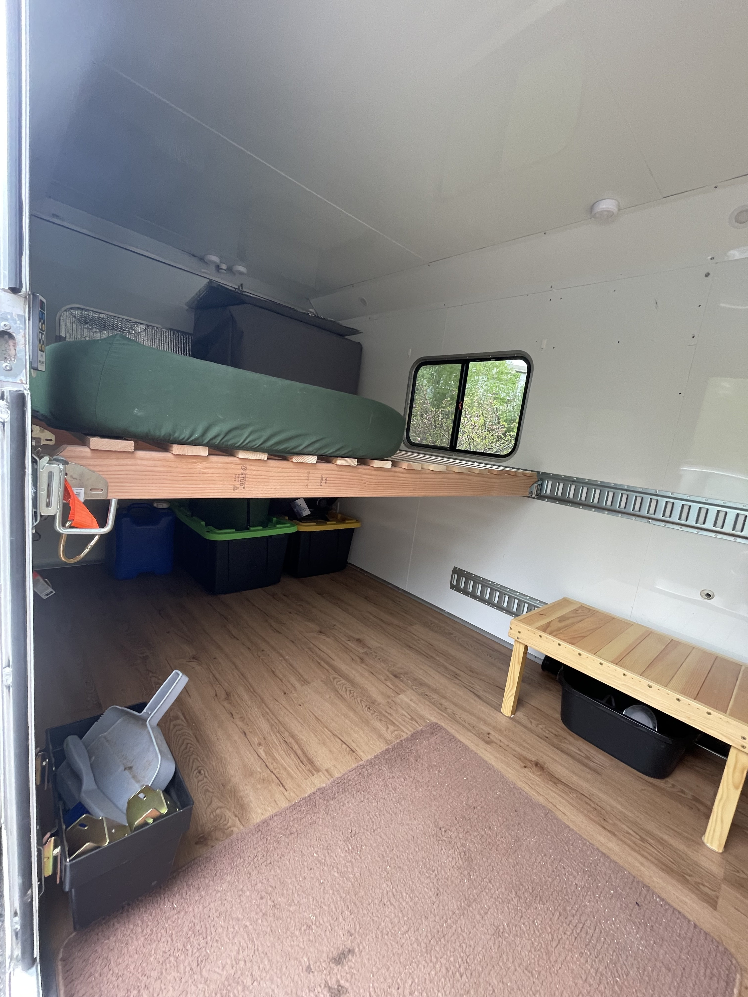 Spacious RV rental interior featuring a wooden bed platform with storage underneath, a window, and wood laminate flooring.. Weeroll Silver cloud 2020