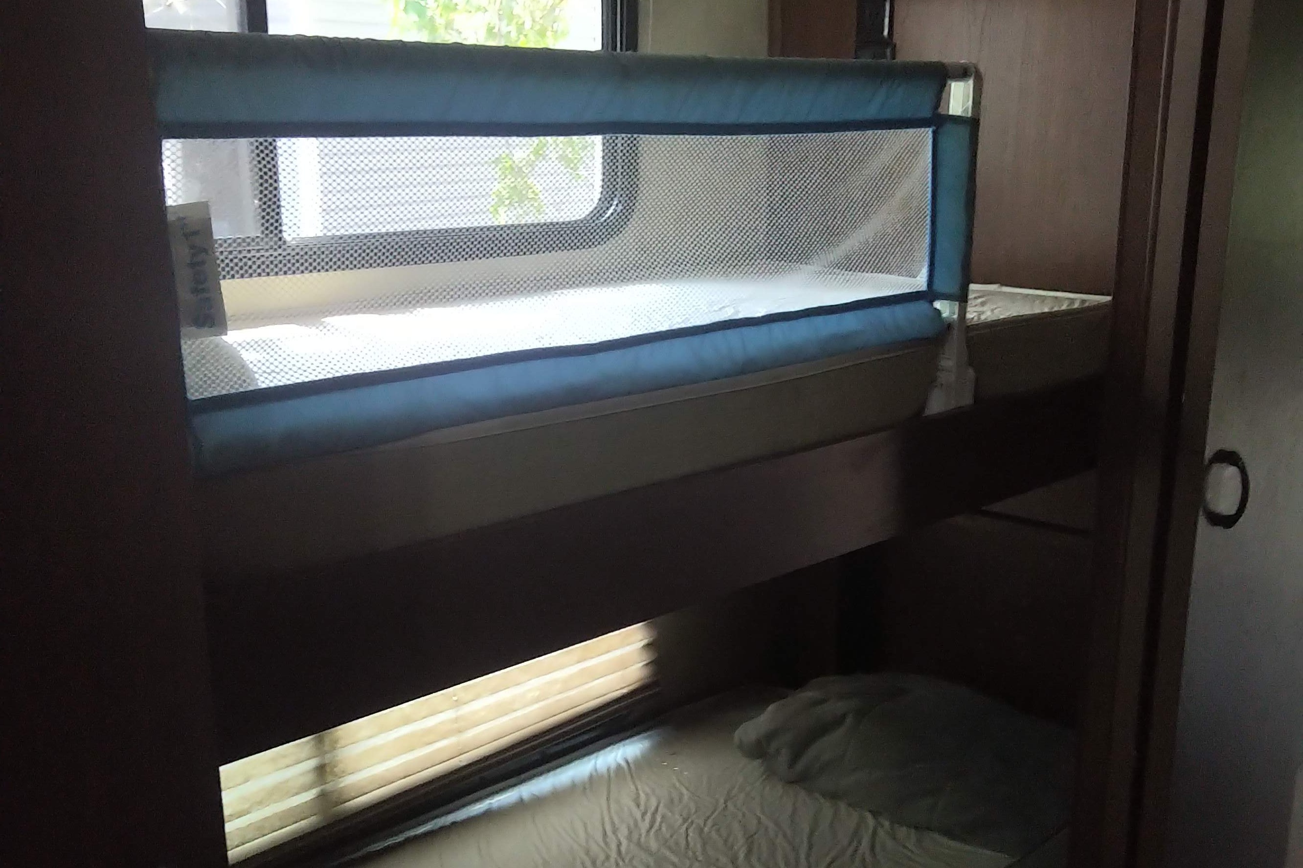 RV rental interior: bunk beds with Safety 1st rail, ensuring safety and comfort for family travel.. Thor Hurricane 2014