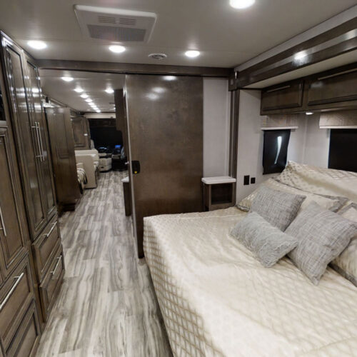 This RV rental offers a spacious bedroom with a sliding door leading to the main living area.. Forest River Georgetown 2022