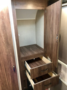 RV rental interior storage: open wood-grain wardrobe and two pull-out drawers. Efficient, compact space for your belongings.. Travel Lite Falcon 2018