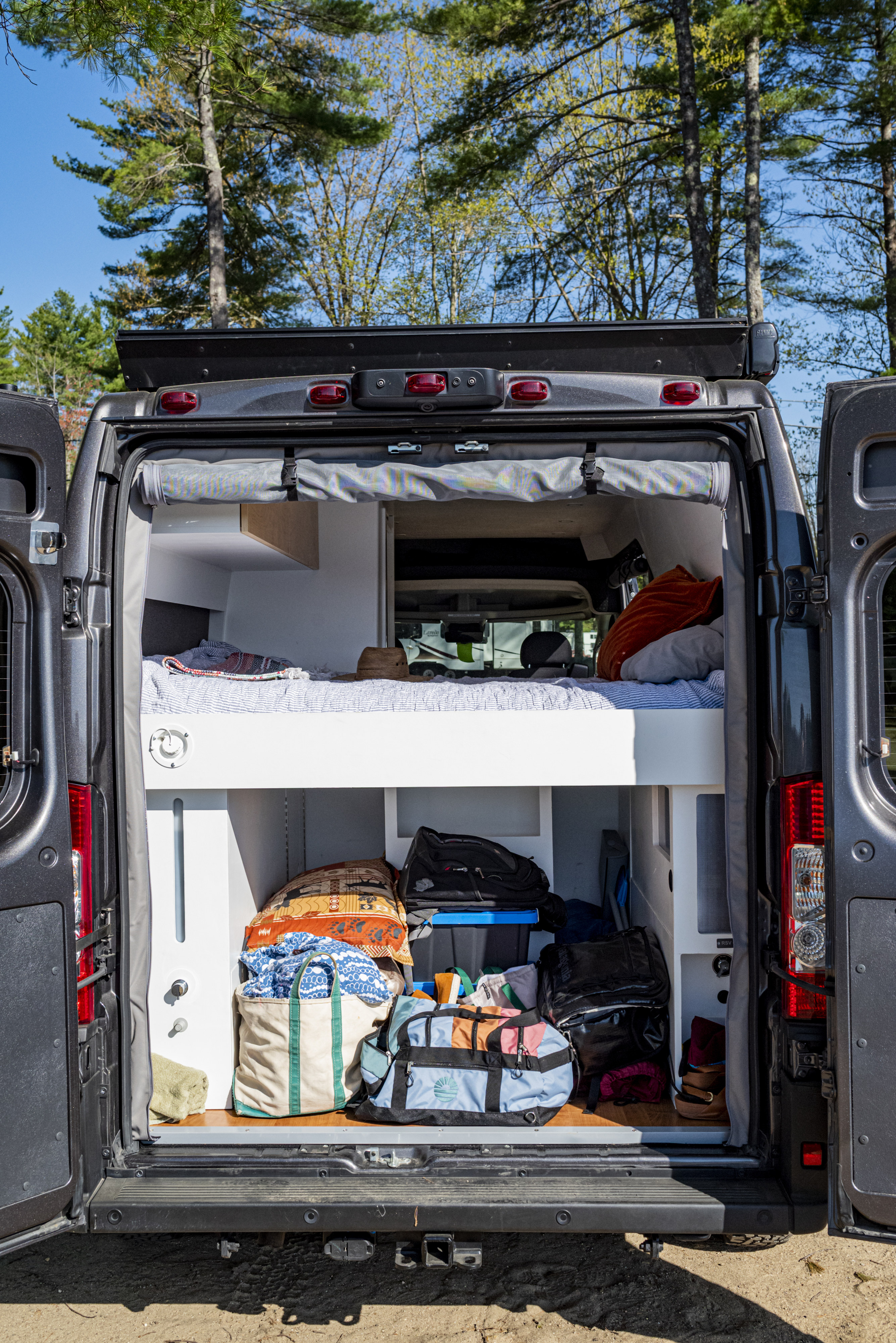 This RV rental offers comfort & utility: a camper van's interior with a cozy bed and smart storage for your adventures.. Dodge Ram Promaster 3500 2021