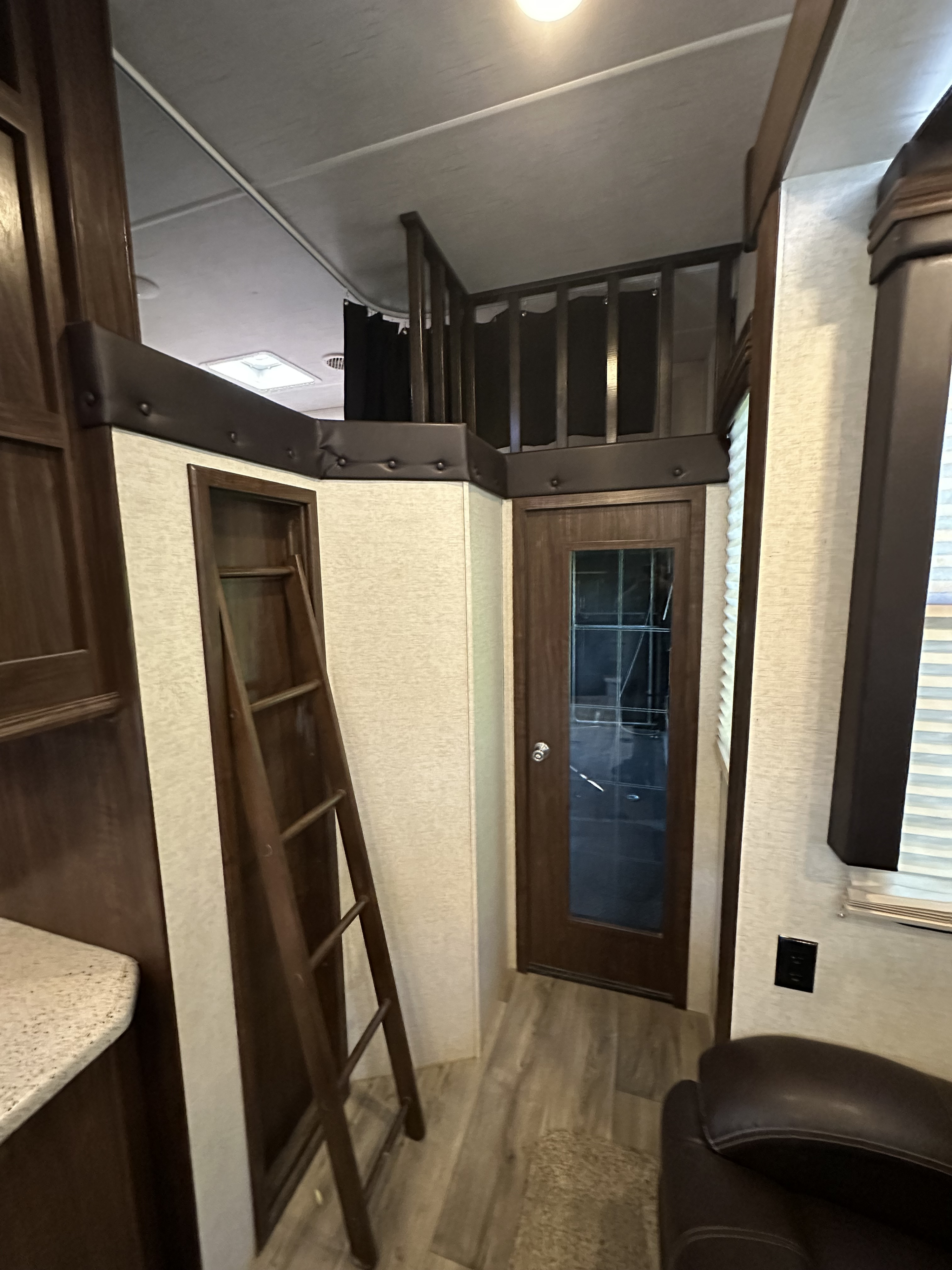 Cozy RV rental interior featuring a clever loft bunk with ladder, a stylish door, and functional living space.. Heartland Torque 2018