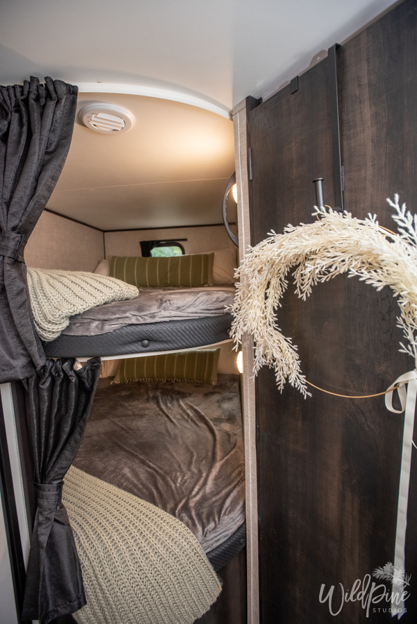 Cozy bunk beds inside an RV rental, complete with soft bedding, pillows, and privacy curtains, ideal for family travel.. Jayco 242BHSW 2023