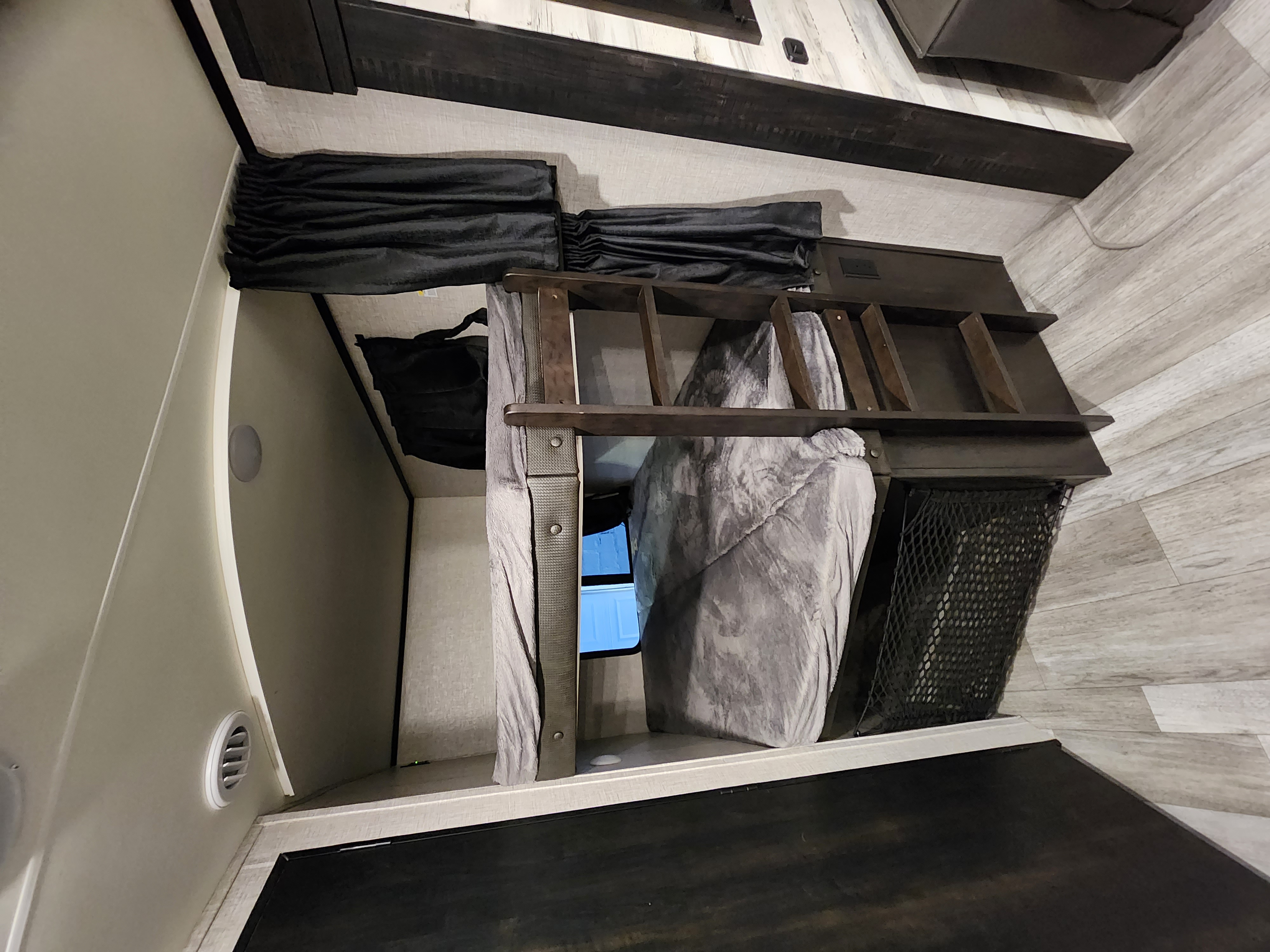 RV rental bunk area: two stacked beds with a ladder, gray bedding, and dark wood accents. Practical for trips.. Jayco Jay Feather 2022