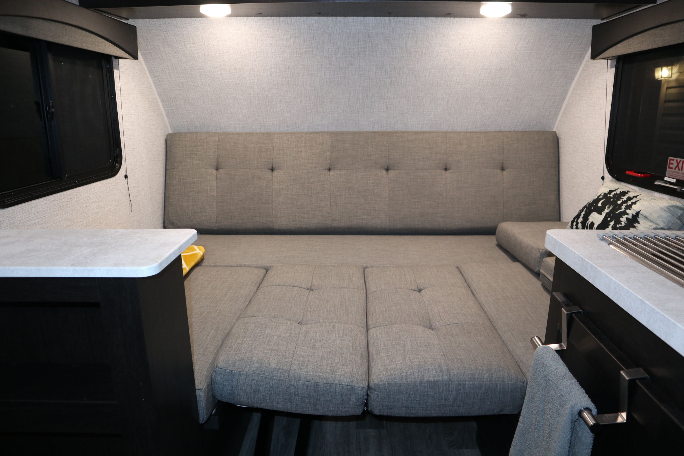 This cozy RV rental interior features a convertible dinette/bed, ideal for compact living and travel.. Braxton Creek Bushwhacker Plus 2022