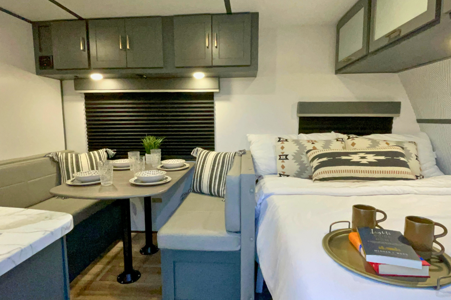 Modern RV rental interior: cozy dining booth & inviting bedroom with southwestern accents.. Keystone RV Bullet Crossfire 2022