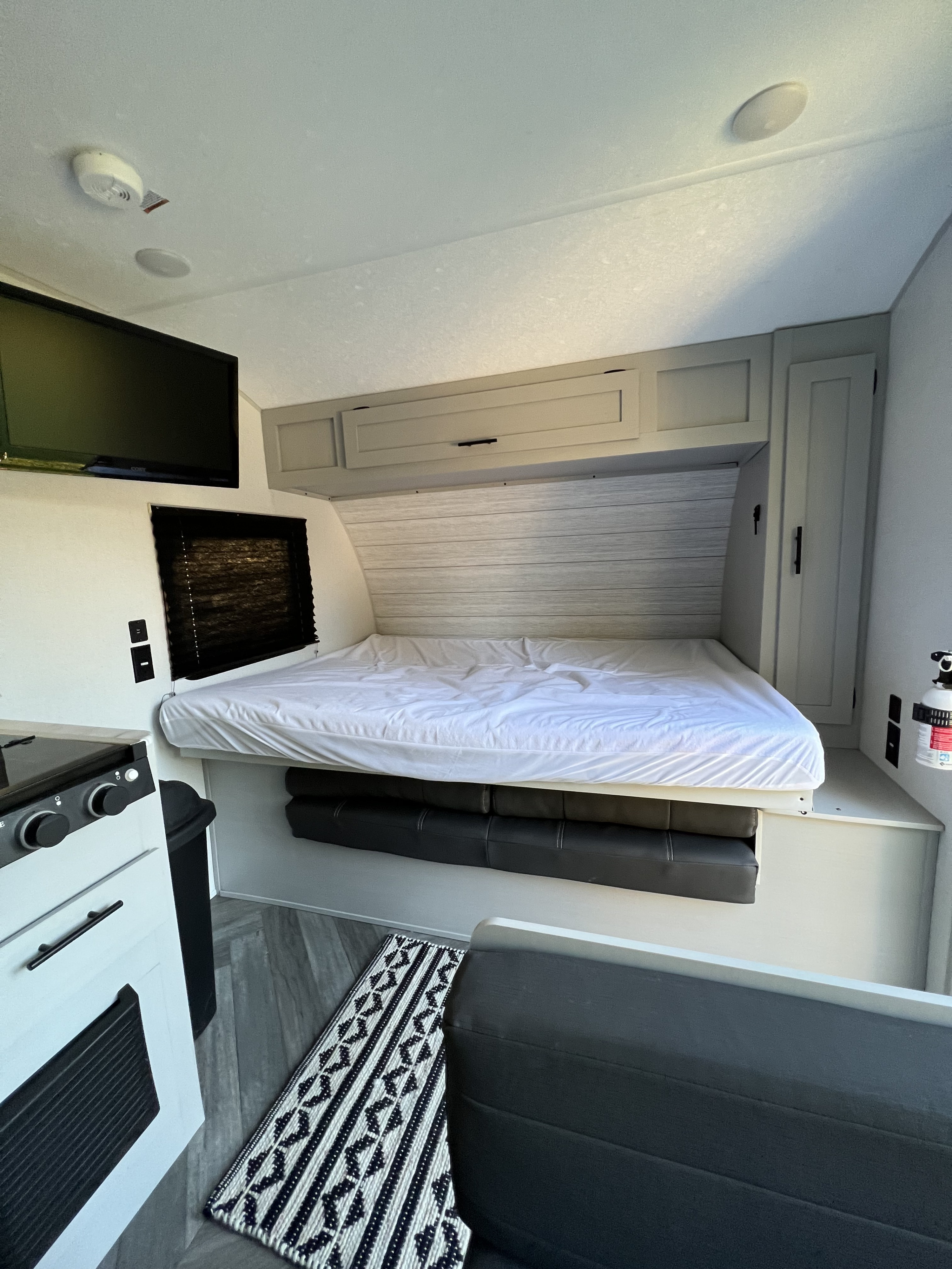 Inside a modern rv rental: convertible bed, integrated kitchen, TV, storage. Compact & comfy for your next adventure.. Forest River Wildwood FSX 2021