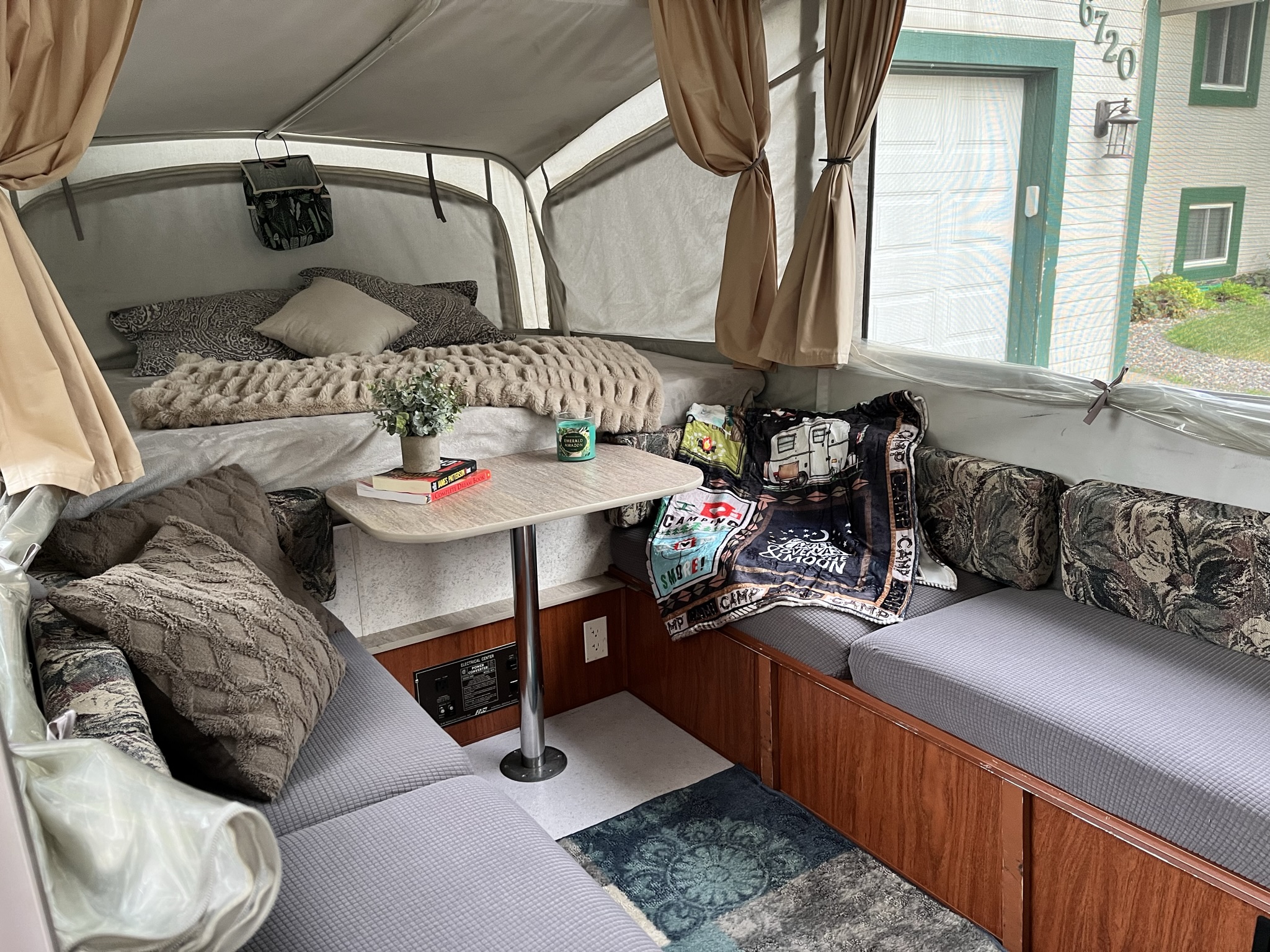 Cozy rv rental interior with bed, dinette, and reading nook, perfect for travel adventure.. Coleman Americana Utah 1995