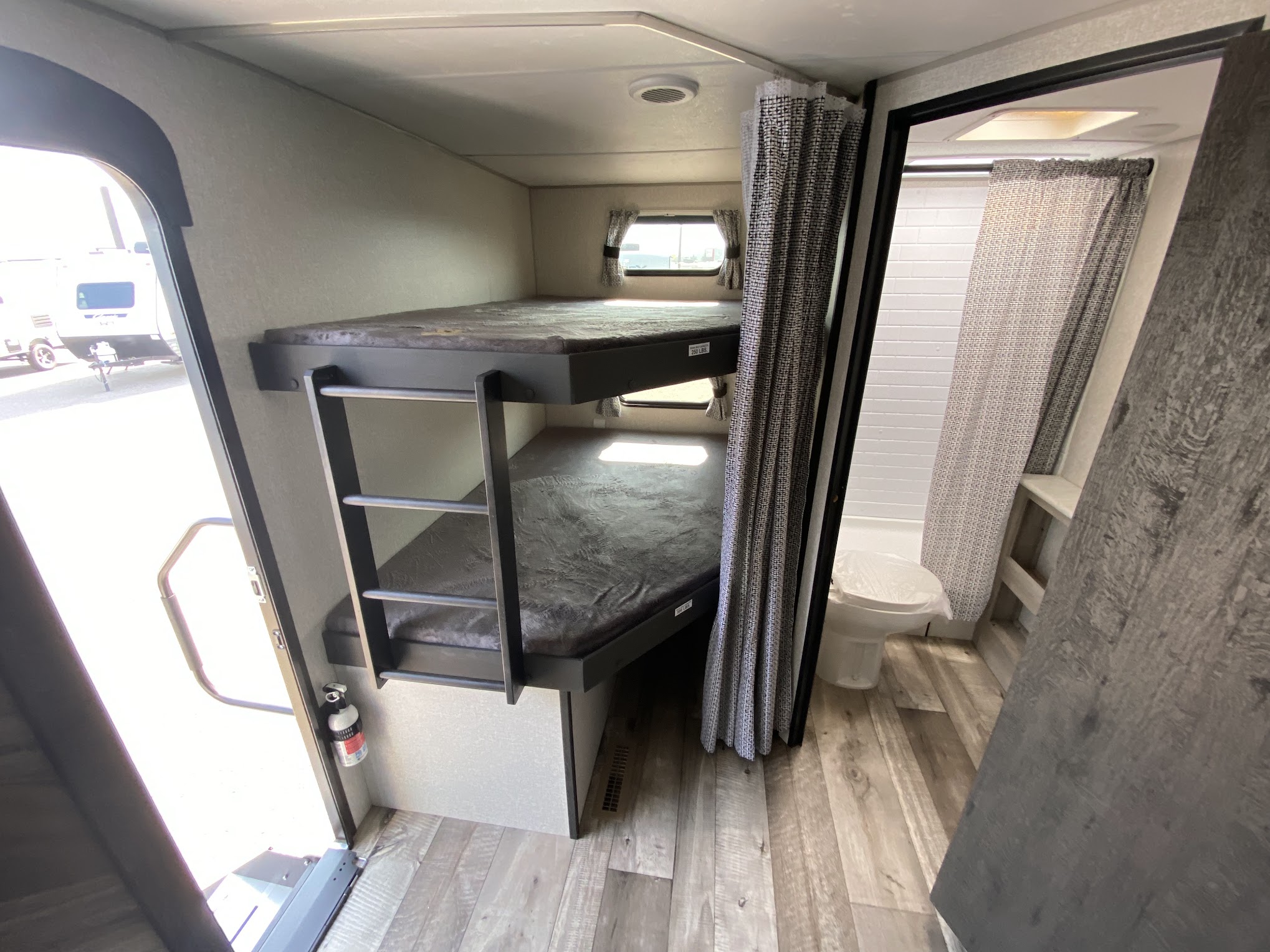 This RV rental showcases its functional interior with bunk beds, ladder, and compact bathroom. Ready for your next camper adventure.. Connect SE 2021