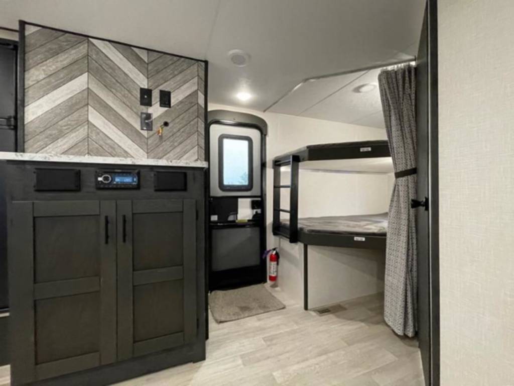 RV rental interior featuring a multimedia console, storage cabinets, and comfortable bunk beds.. Connect SE 2021