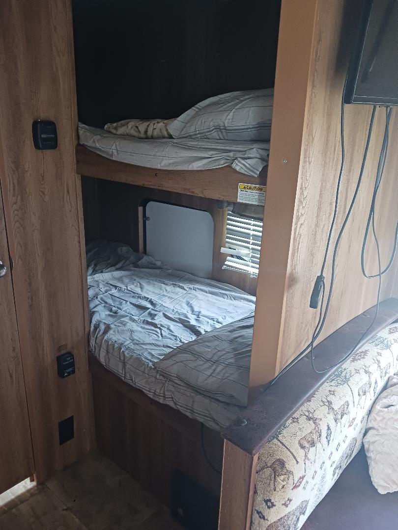 Cozy bunk beds inside an RV rental, offering comfortable sleeping arrangements in this compact travel trailer interior.. Keystone RV Hideout LHS 2016