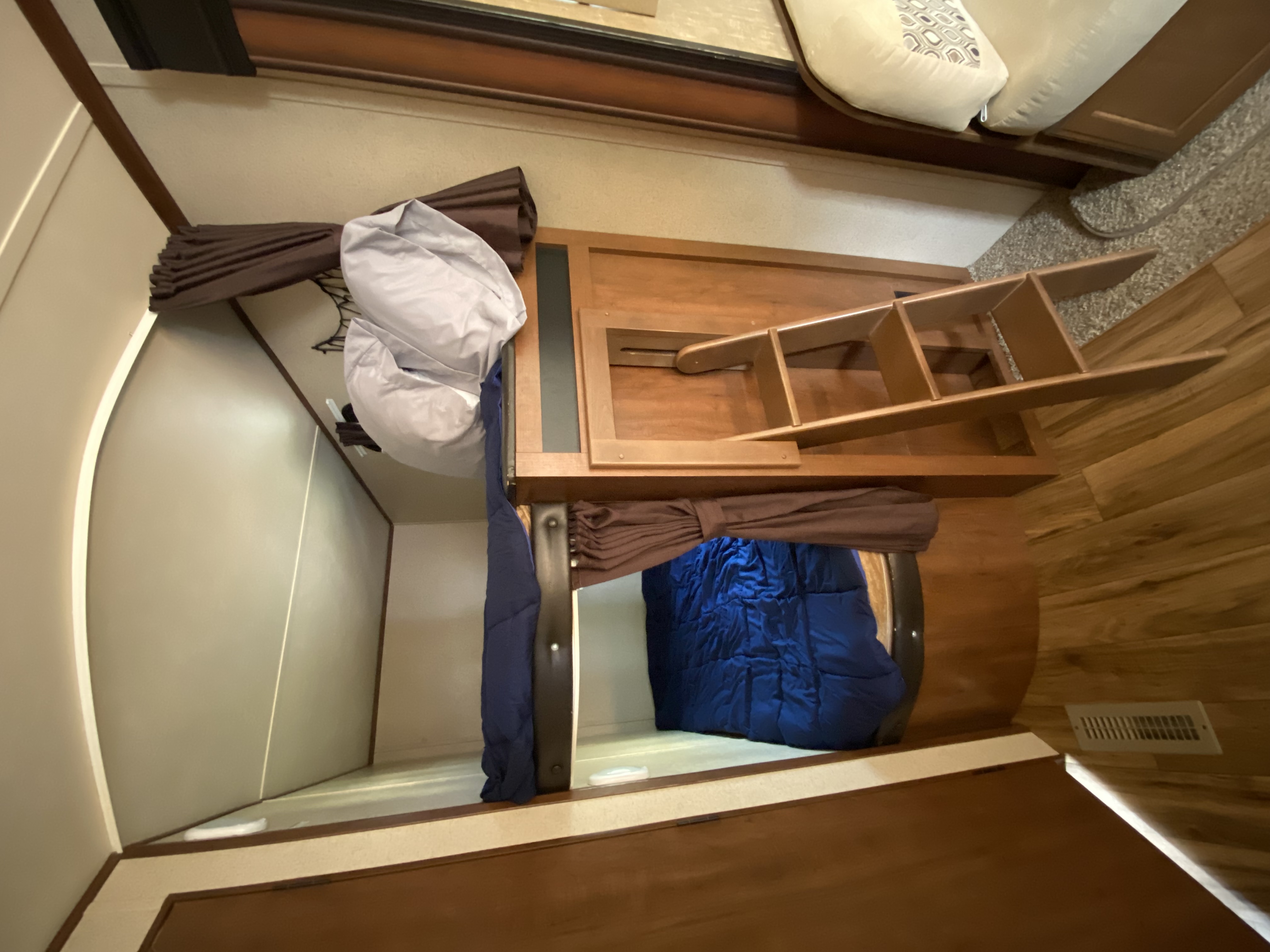 RV rental interior: Two cozy bunk beds with a wooden ladder for convenient access in a light wood setting.. Jayco Jay Flight 2015
