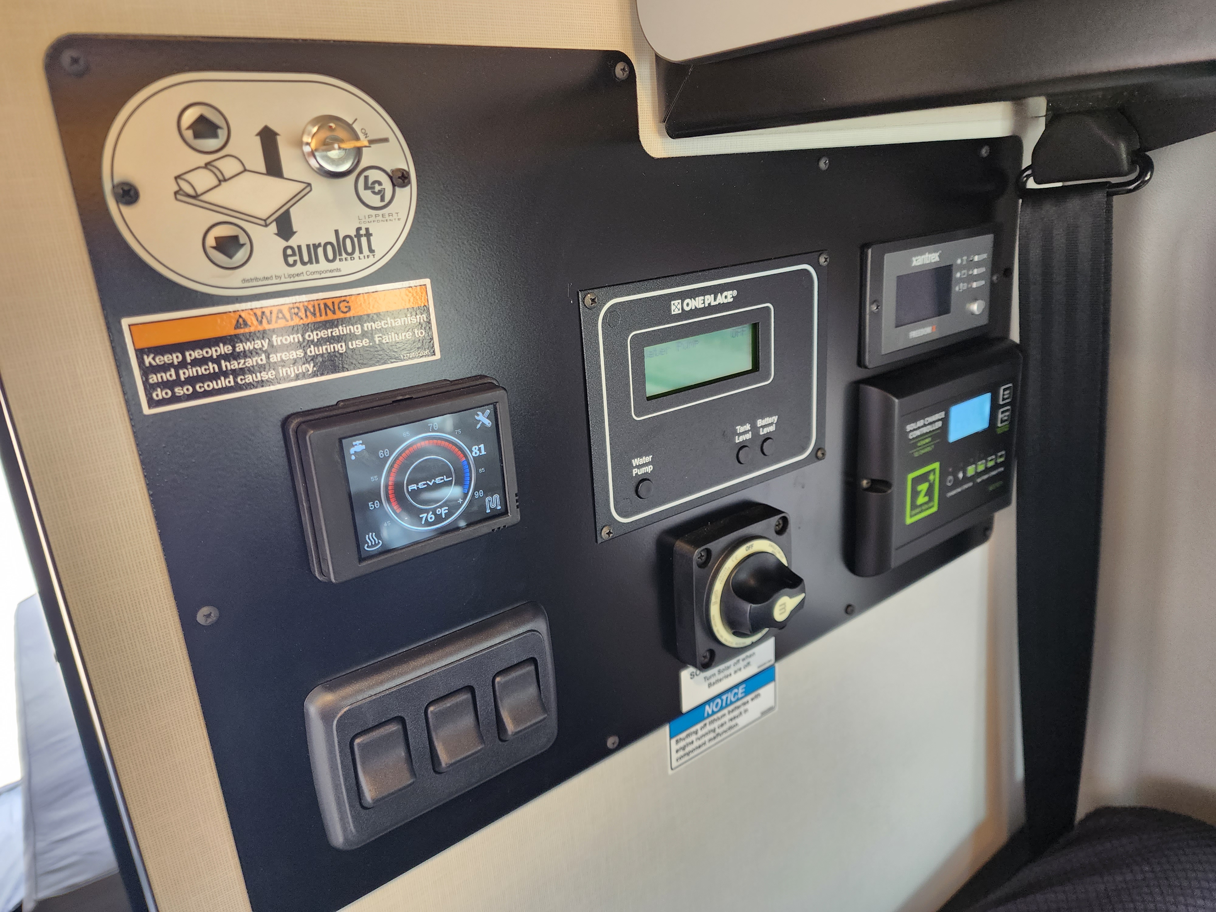 RV rental control panel features a Euroloft bed lift, Revel monitor, OnePlace system, and solar/battery controls.. Winnebago Revel 2023
