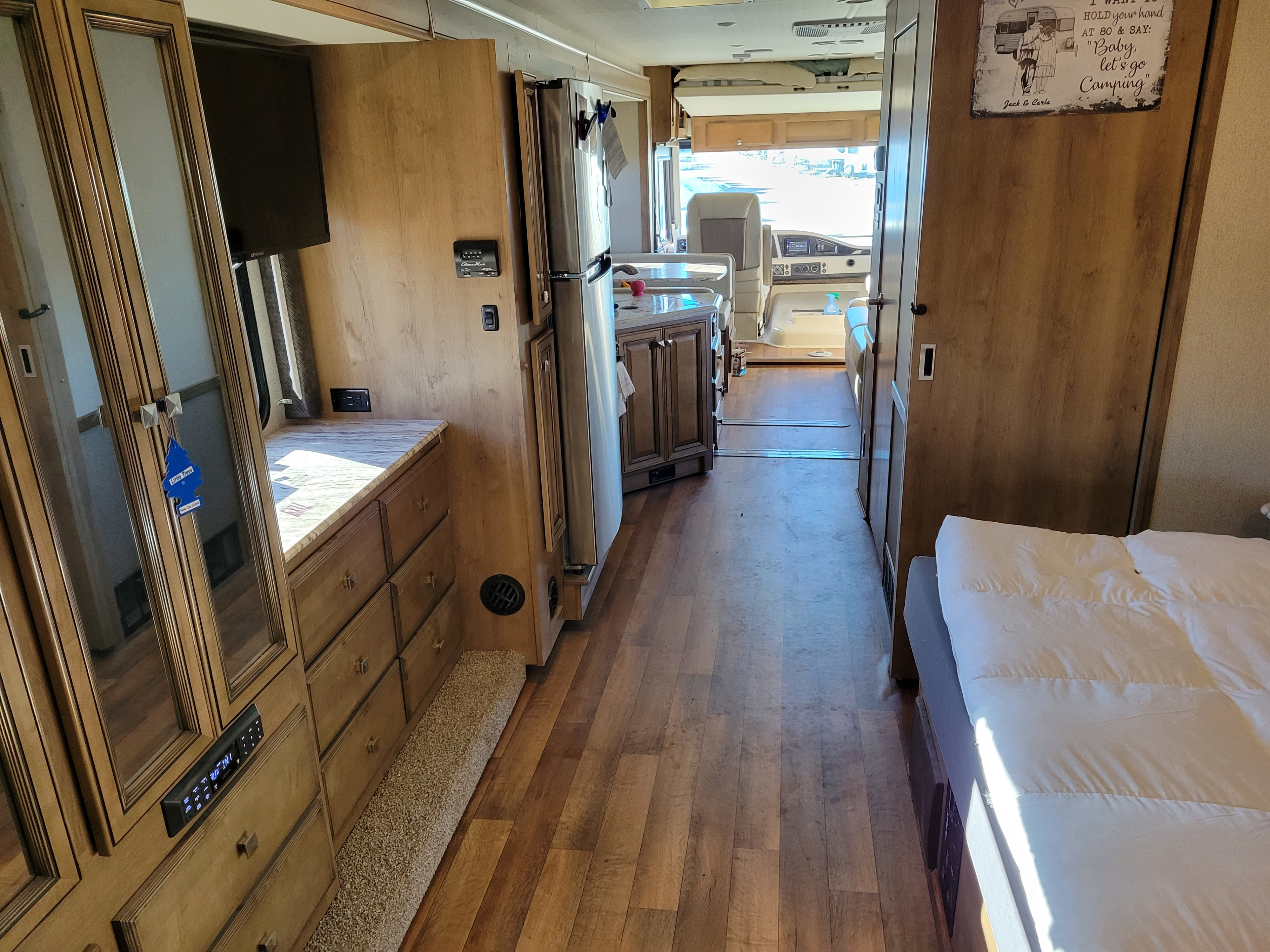 Inside a well-appointed rv rental, featuring a full kitchen, comfortable bed, and spacious walkway leading to the cockpit.. Fleetwood Flair 32S 2019