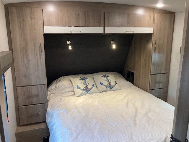 RV rental bedroom: Cozy bed, built-in storage, and lighting for comfortable travel.. Grand Design Imagine 2022