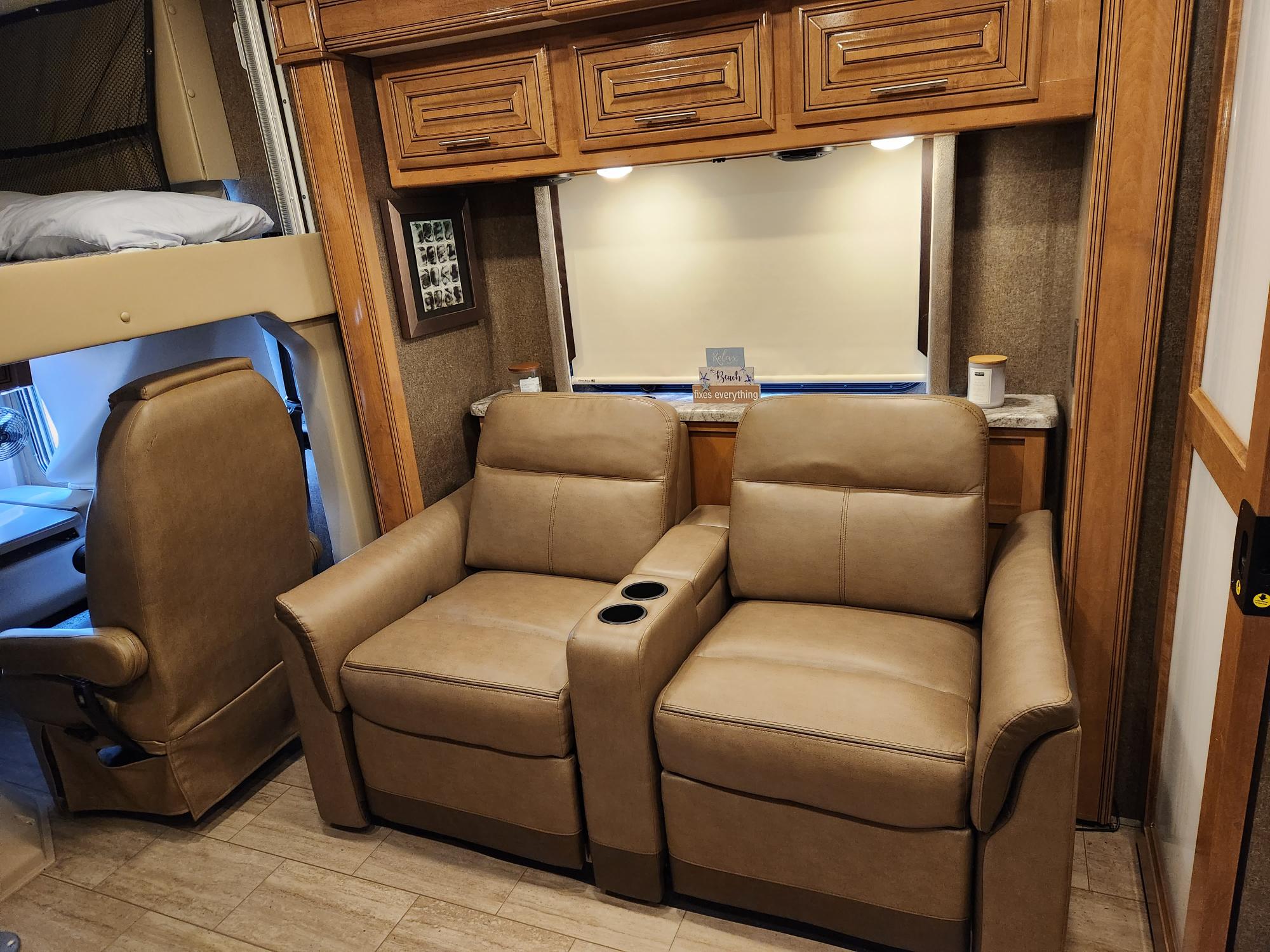 Enjoy a comfortable RV rental interior with plush recliners, a bunk bed, and ample storage cabinets for your travels.. Thor Challenger 2019